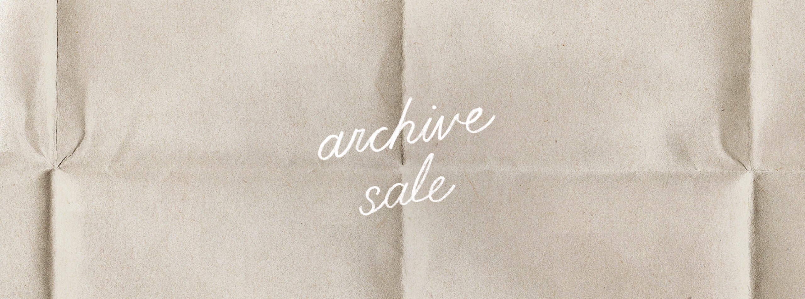 A textured beige background resembling folded paper with the words 'archive sale' written in white cursive script in the center.