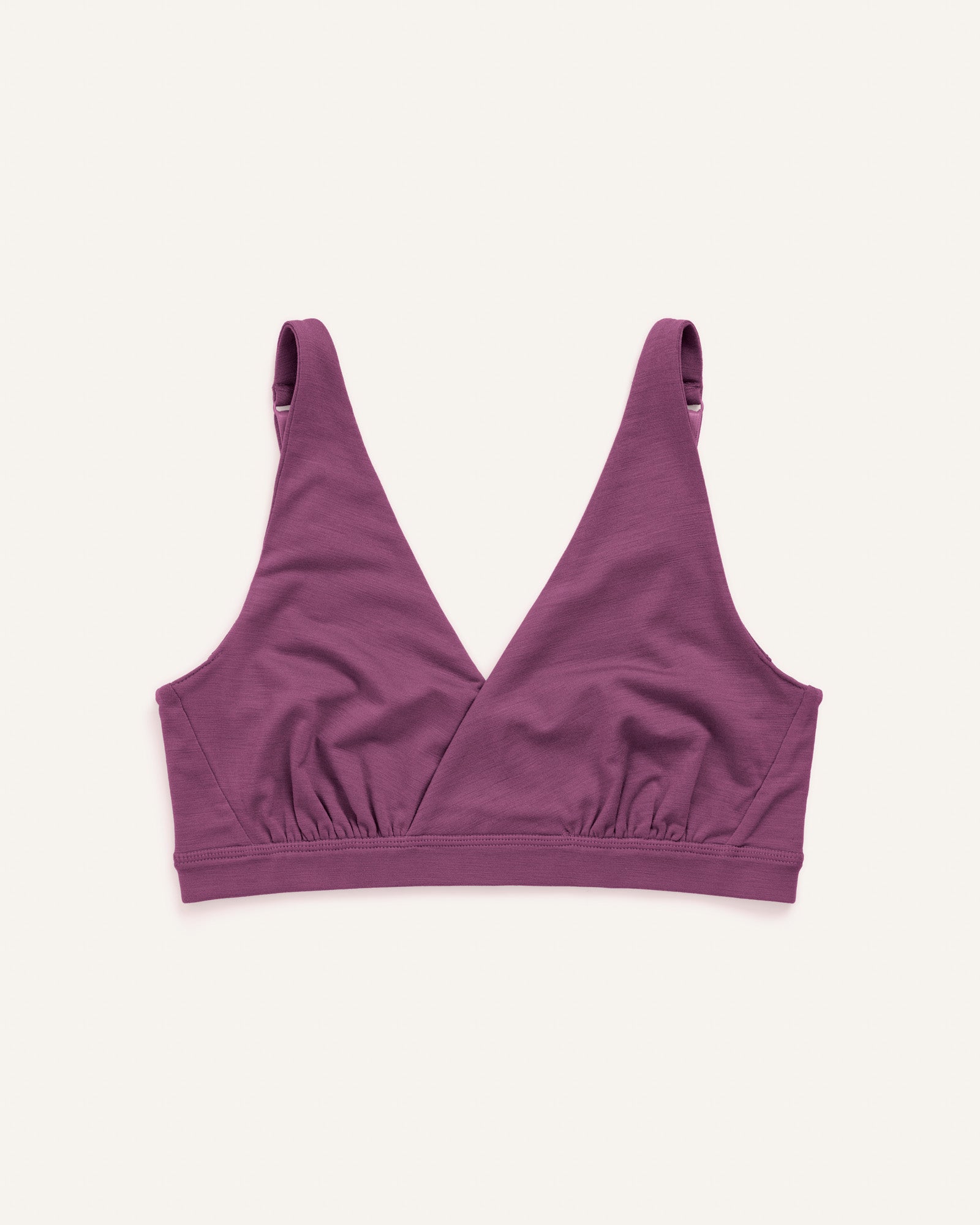 Laydown of Roam Convertible Wrap Bra in Plum, a berry pink-purple color. Roam Convertible Wrap Bra is a merino wool underwear available in sizes XS-XXL.