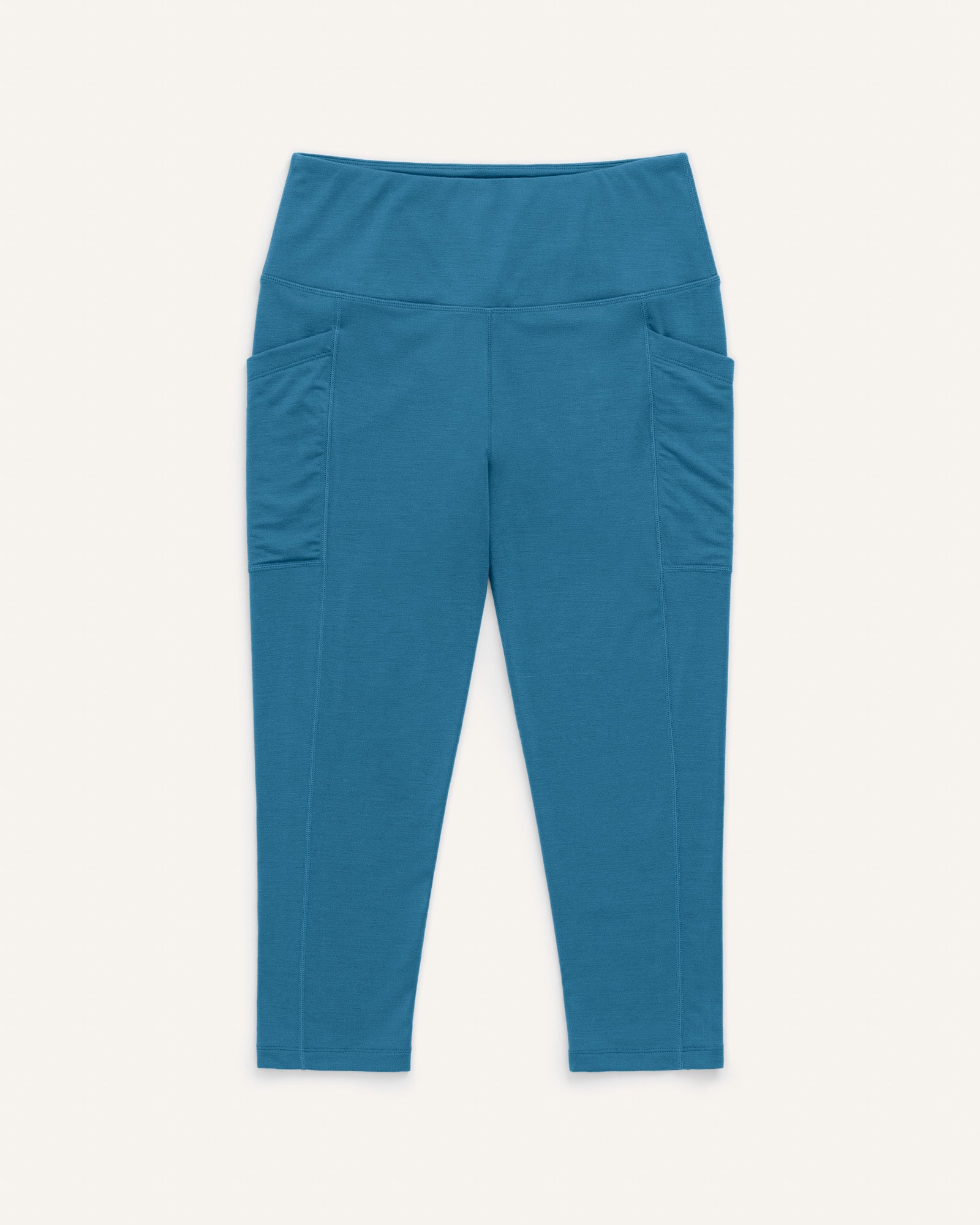 Laydown of Summit Pocket Crop Legging in Ocean Teal, a medium blue-green color. Summit Pocket Crop Legging is a merino wool legging with pockets available in sizes XS-3X.