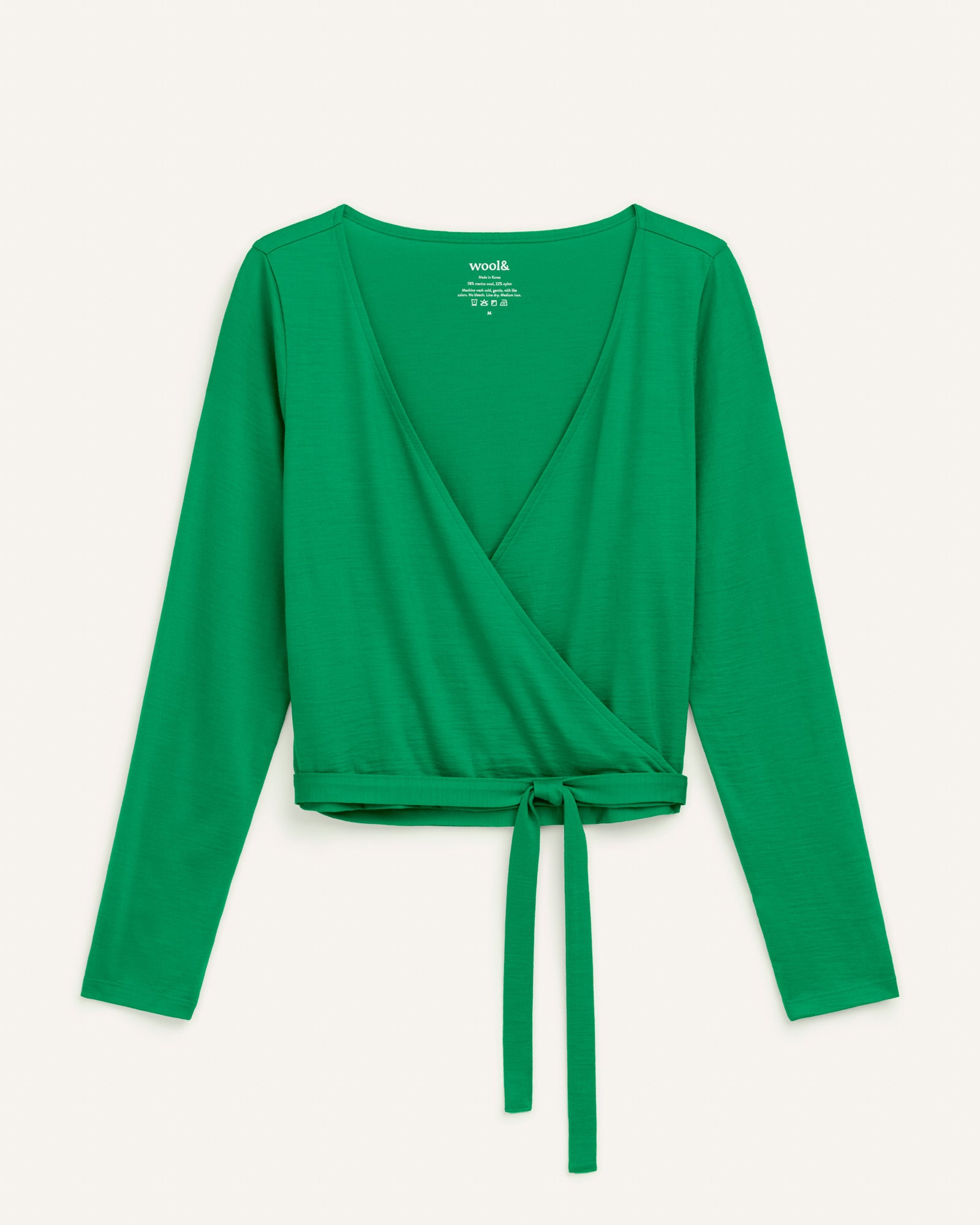 Laydown of Natalia Wrap Top in Verde, a bright Kelly green color. Natalia Wrap Top is a merino wool long sleeve, v-neck, slim fit top available in sizes XS-3X.