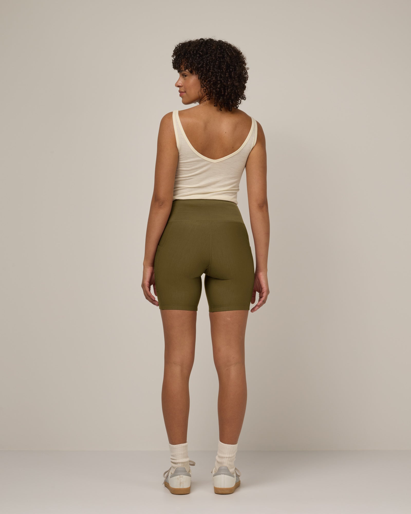 Model wearing Summit Pocket Bike Short in Olive. Summit Pocket Bike Short is a merino wool short with pockets available in sizes XS-3X.