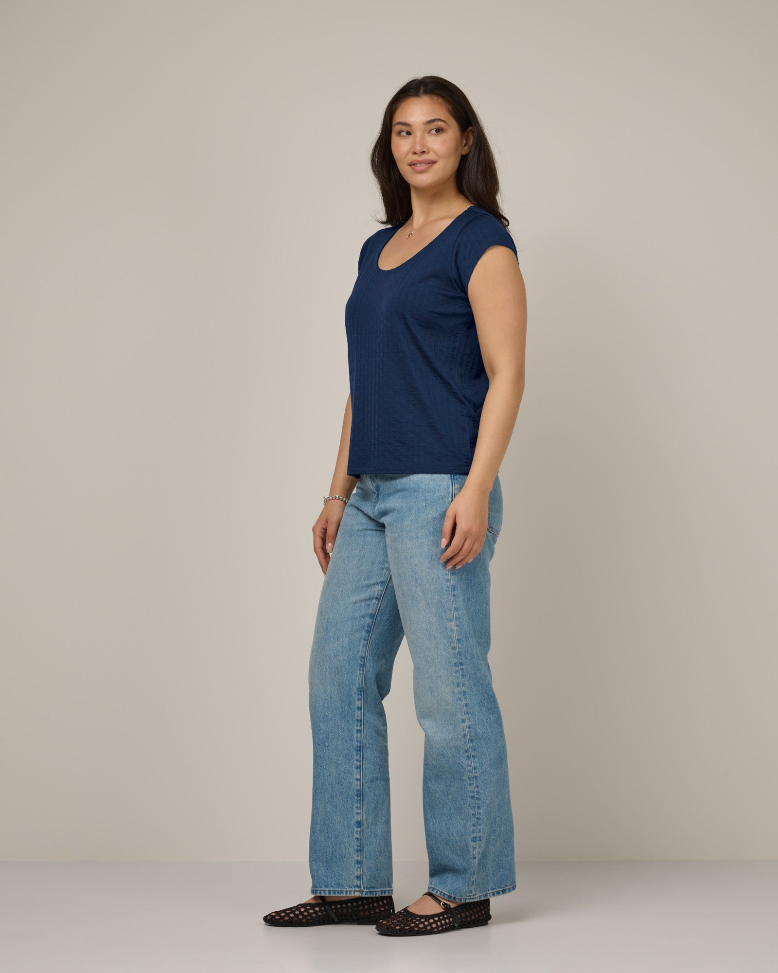 Model wearing Savanna Cap Sleeve Tee in Marine Blue, a deep royal blue color. Savanna Cap Sleeve Tee is a merino wool short sleeve, scoop neck, regular fit tee available in sizes XS-XXL.