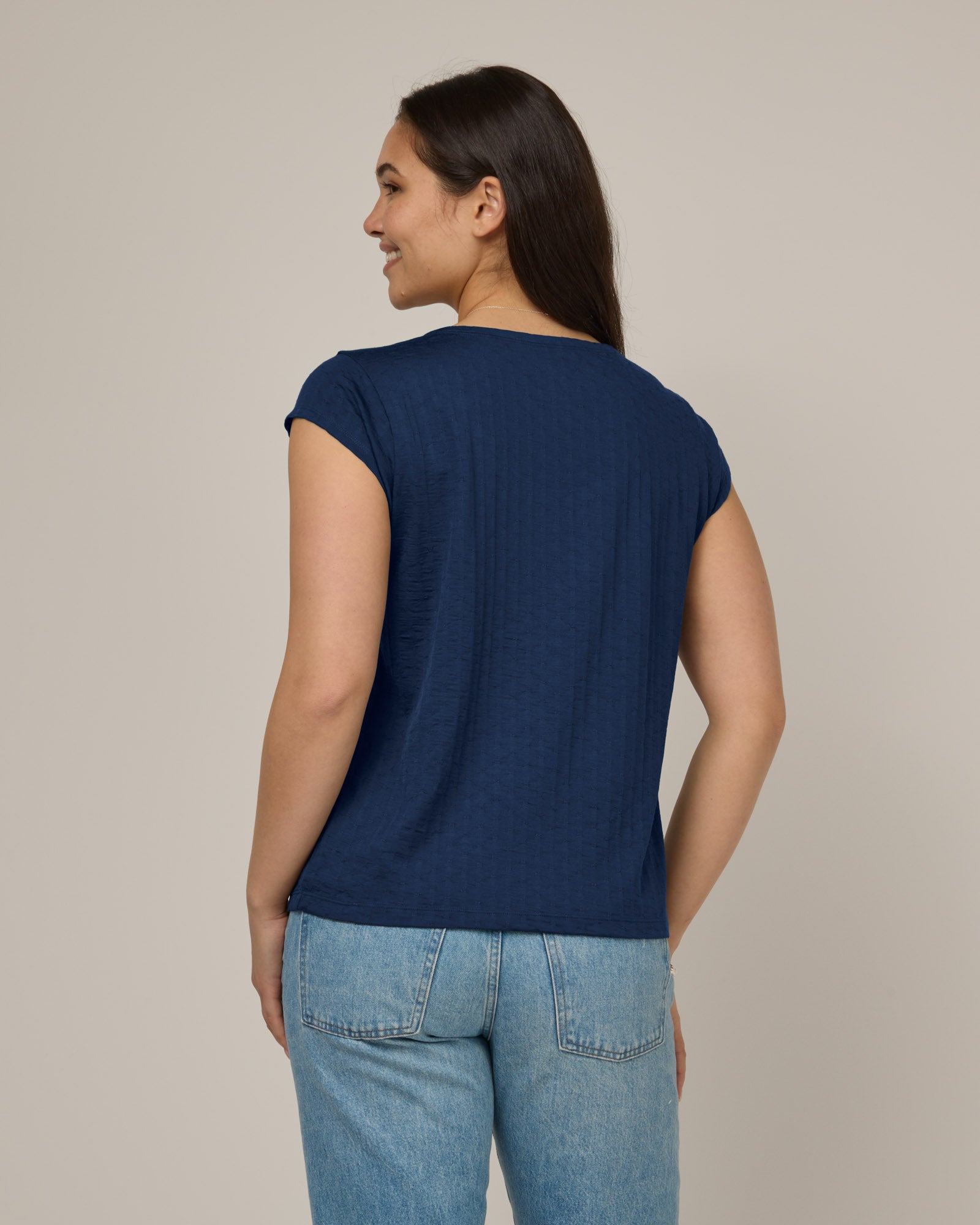 Model wearing Savanna Cap Sleeve Tee in Marine Blue, a deep royal blue color. Savanna Cap Sleeve Tee is a merino wool short sleeve, scoop neck, regular fit tee available in sizes XS-XXL.