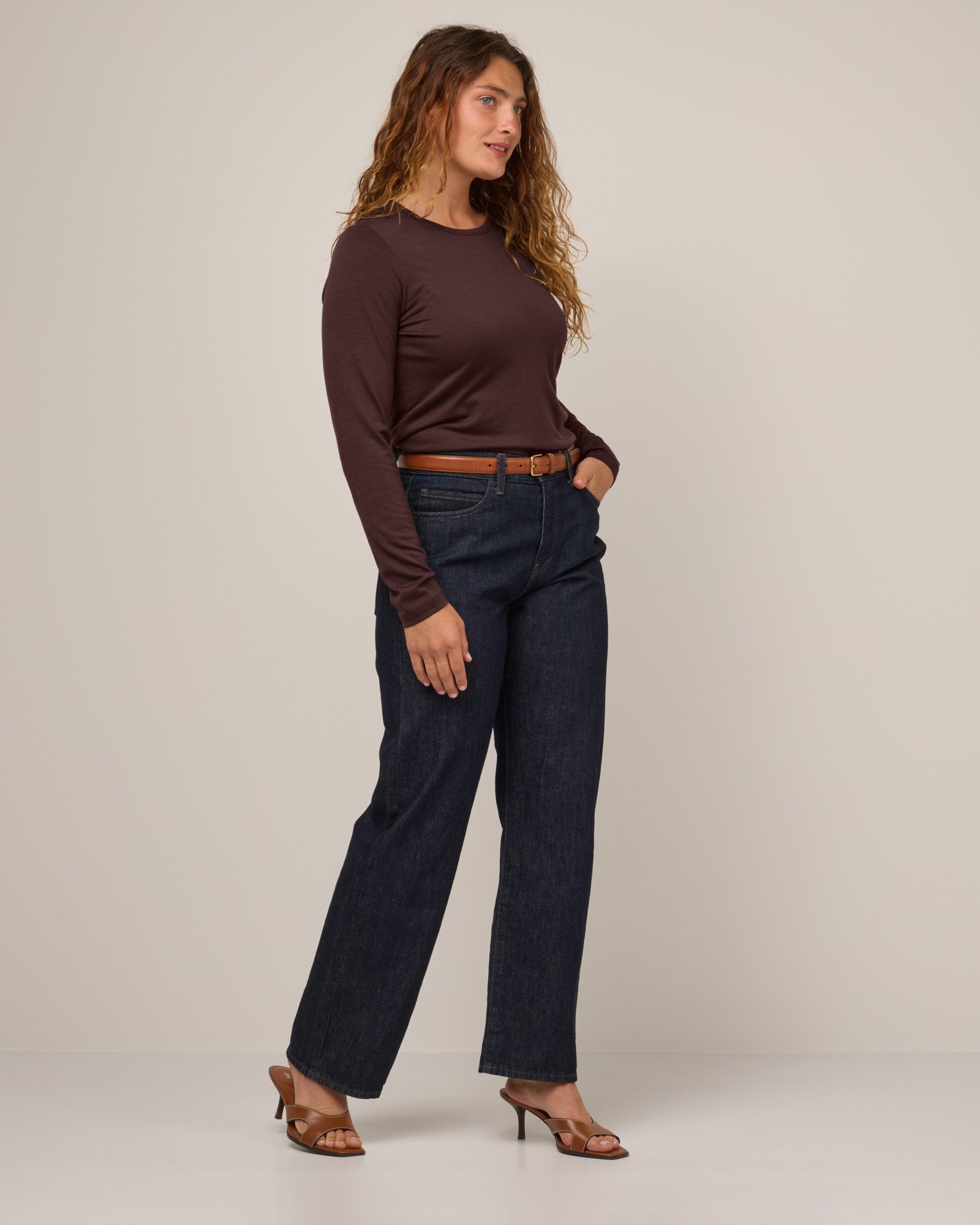 Model wearing Sloan 100% Fitted Tee in Espresso, a warm dark brown color. Sloan 100% Fitted Tee is a merino wool long sleeve, crew neck, slim fit tee available in sizes XS-3X.
