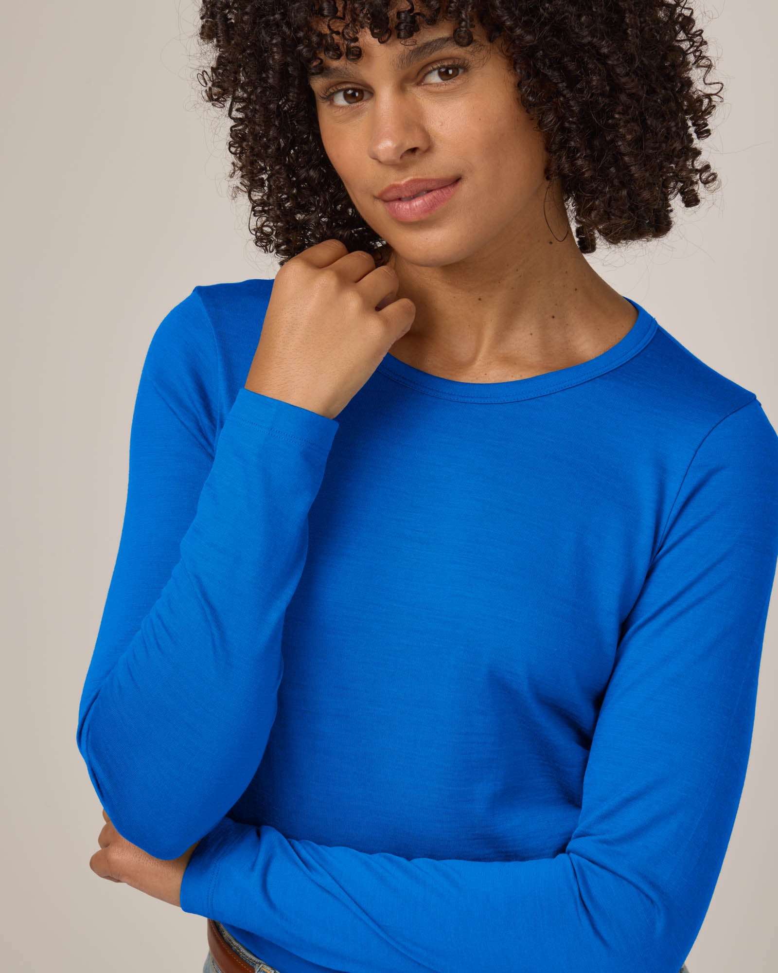 Model wearing Sloan Signature Fitted Tee in Ultramarine, a vibrant cobalt blue color. Sloan Signature Fitted Tee is a merino wool long sleeve, crew neck, slim fit tee available in sizes XS-3X.