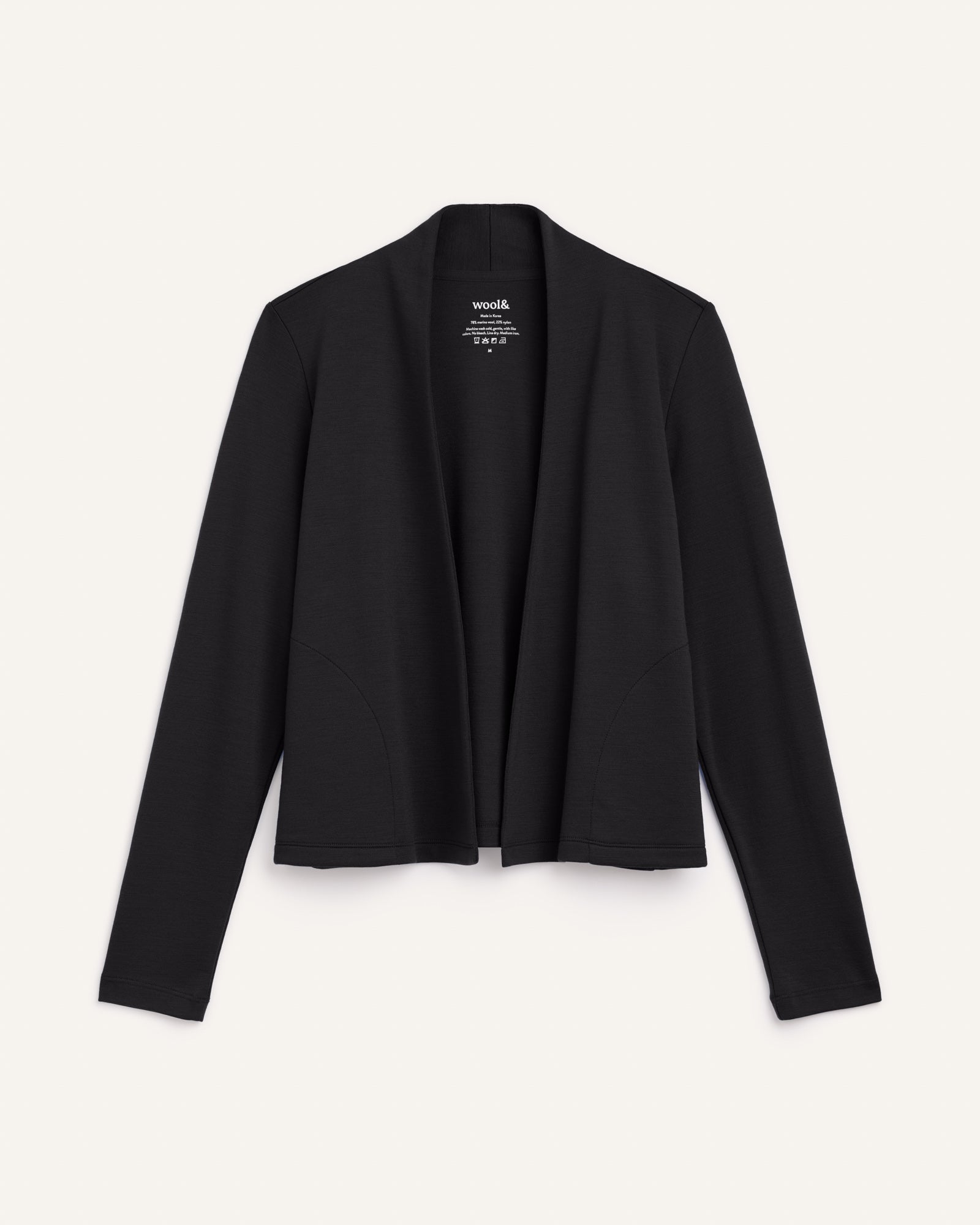 Laydown of Winona Crop Cardigan in Black. Winona Crop Cardigan is a merino wool cardigan with pockets available in sizes XS-XXL.