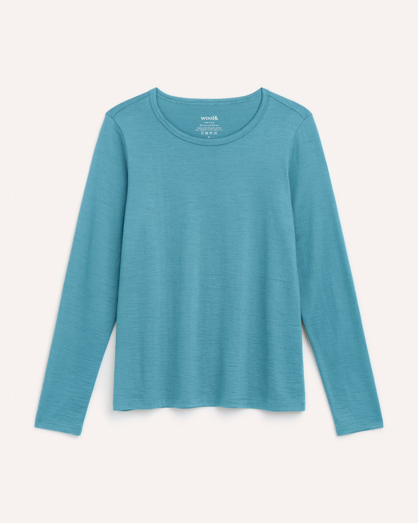 Laydown of Sloan Signature Fitted Tee in Alpine Blue, a glacier ice blue color. Sloan Signature Fitted Tee is a merino wool long sleeve, crew neck, slim fit tee available in sizes XS-3X.