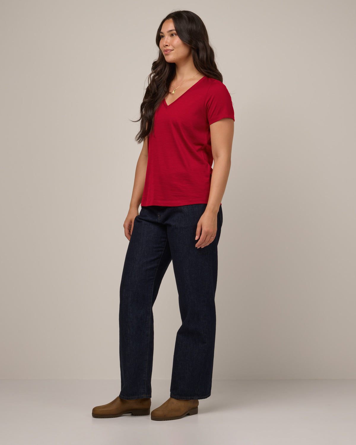 Model wearing Morgan V-Neck Tee in Cherry Red, a bright red color. Morgan V-Neck Tee is a merino wool short sleeve, v-neck, regular fit tee available in sizes XS-3X.