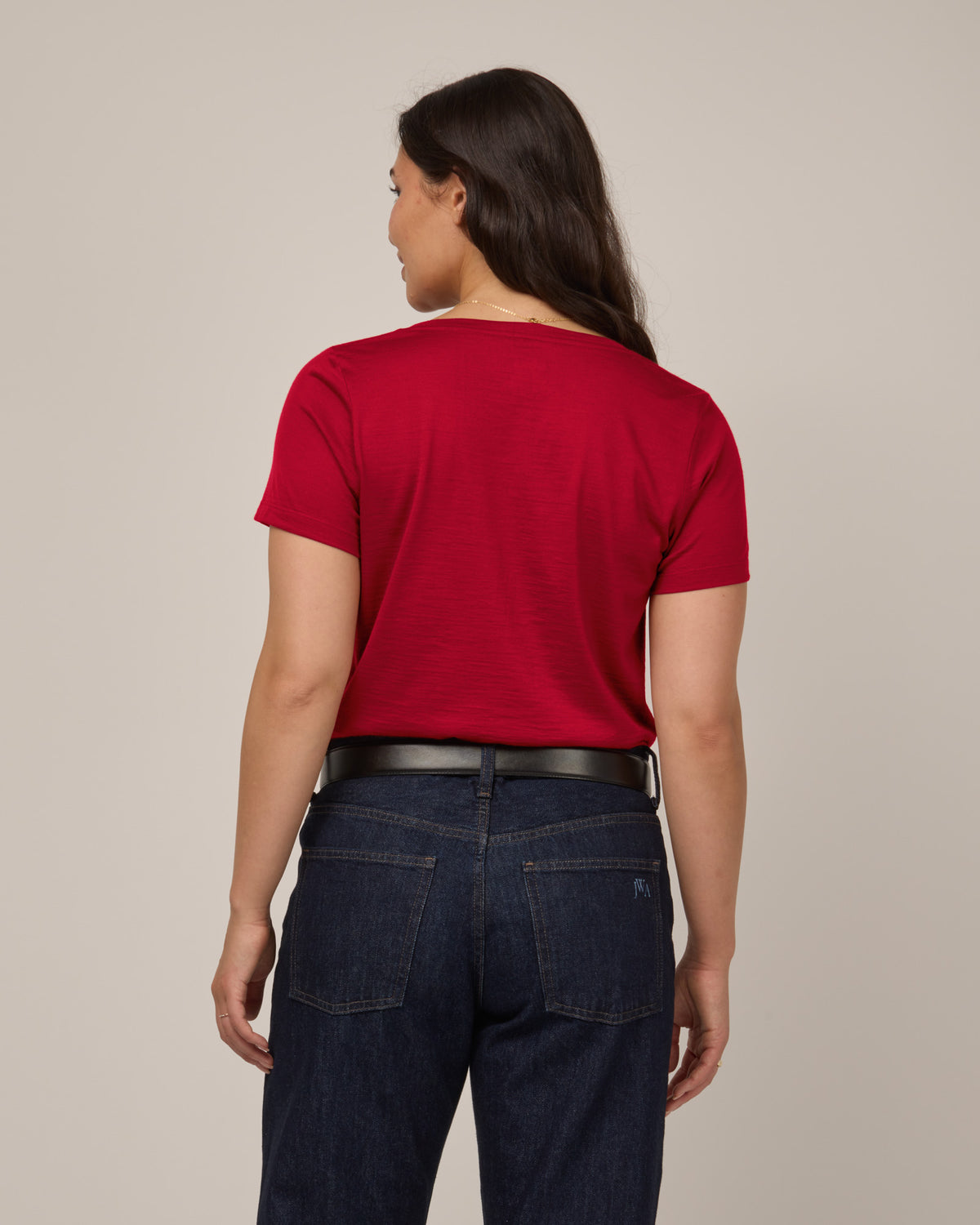 Model wearing Morgan V-Neck Tee in Cherry Red, a bright red color. Morgan V-Neck Tee is a merino wool short sleeve, v-neck, regular fit tee available in sizes XS-3X.