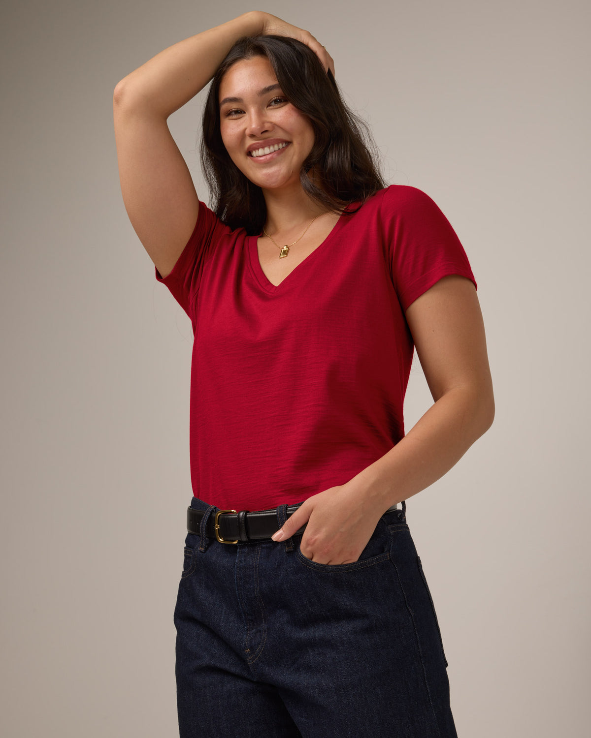 Model wearing Morgan V-Neck Tee in Cherry Red, a bright red color. Morgan V-Neck Tee is a merino wool short sleeve, v-neck, regular fit tee available in sizes XS-3X.