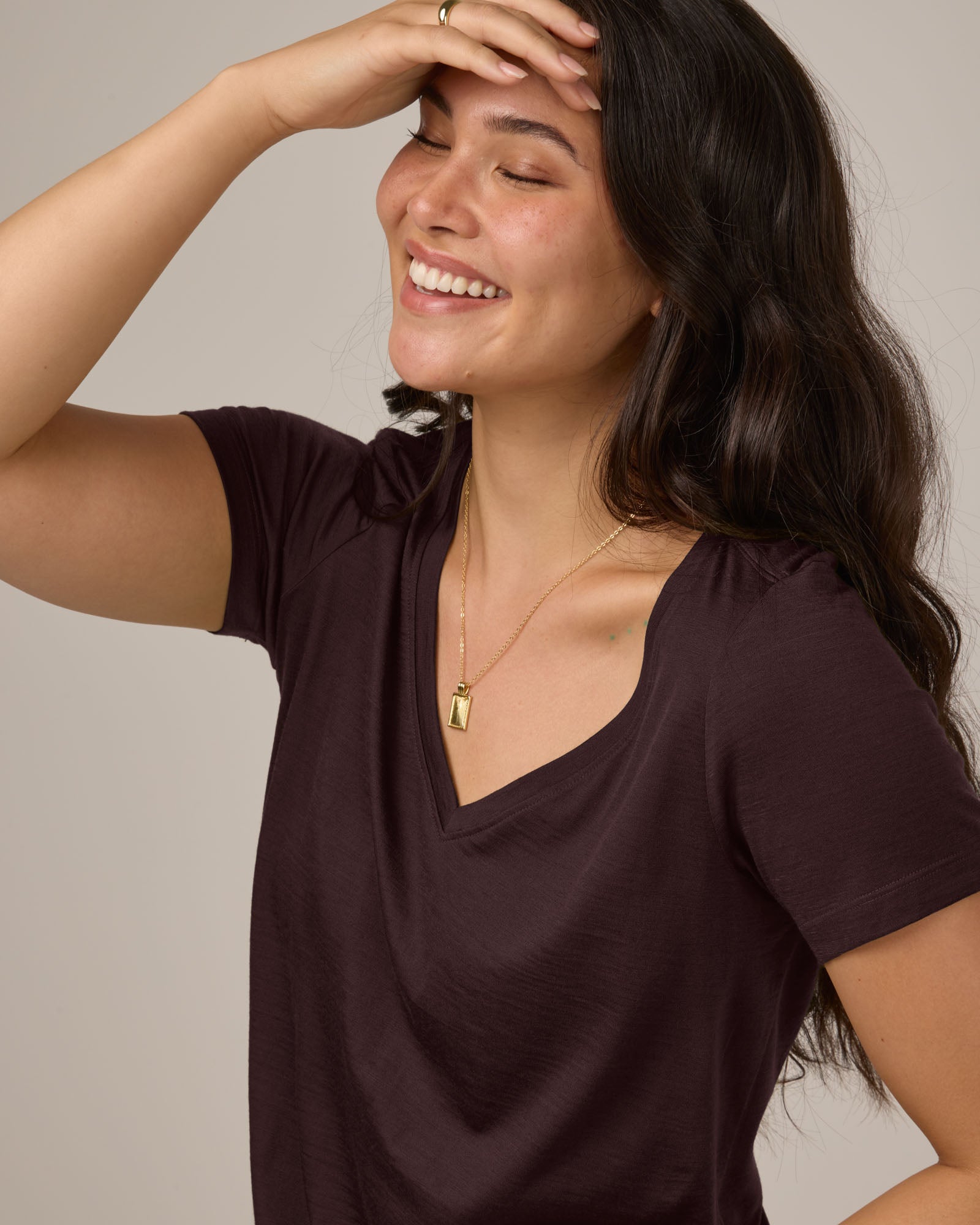 Model wearing Morgan V-Neck Tee in Espresso, a warm dark brown color. Morgan V-Neck Tee is a merino wool short sleeve, v-neck, regular fit tee available in sizes XS-3X.