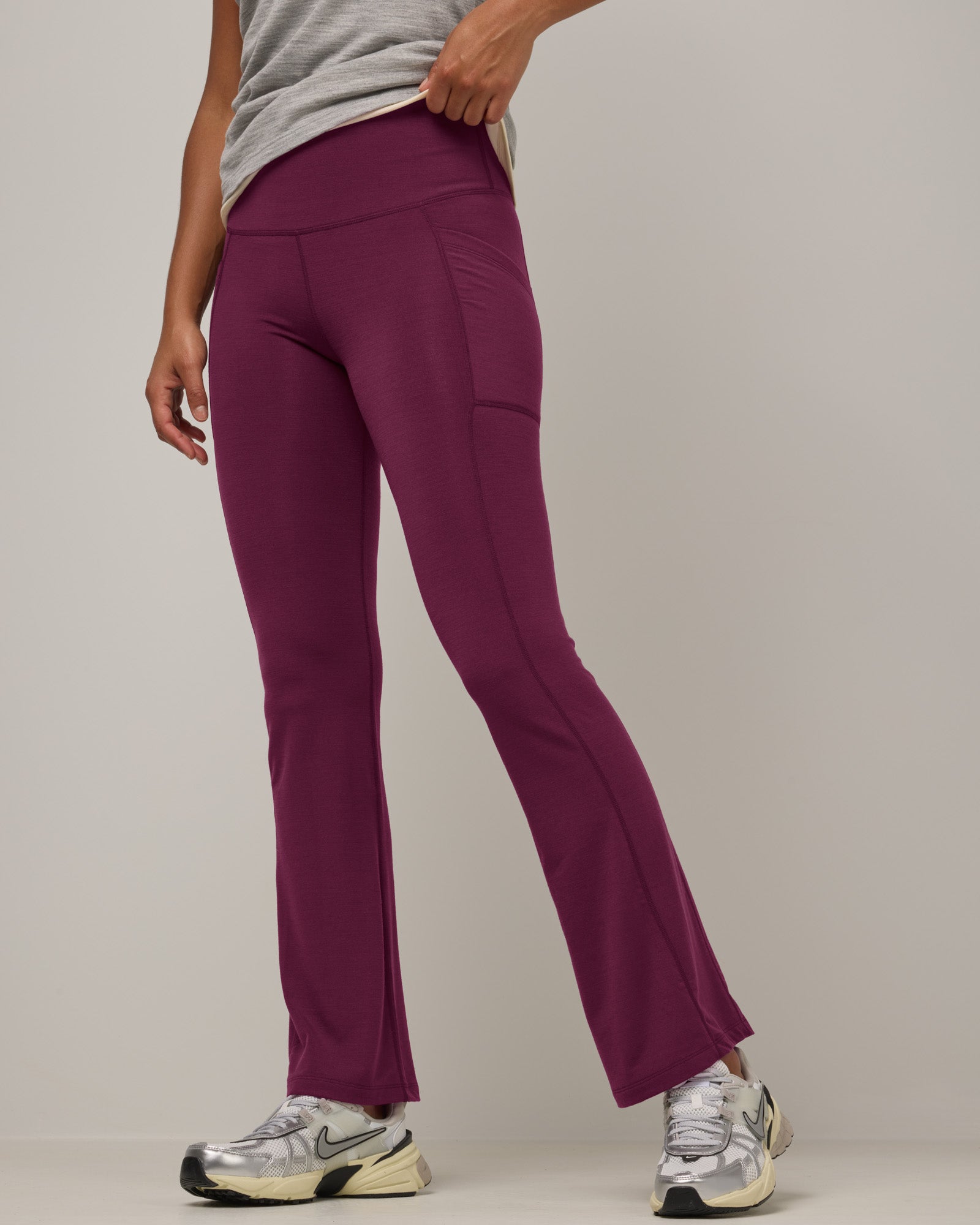 Model wearing Summit Straight Cut Pocket Legging in Plum, a purplish-red color. Summit Straight Cut Pocket Legging is a merino wool legging with pockets available in sizes XS-3X Regular, S-XXL Long.
