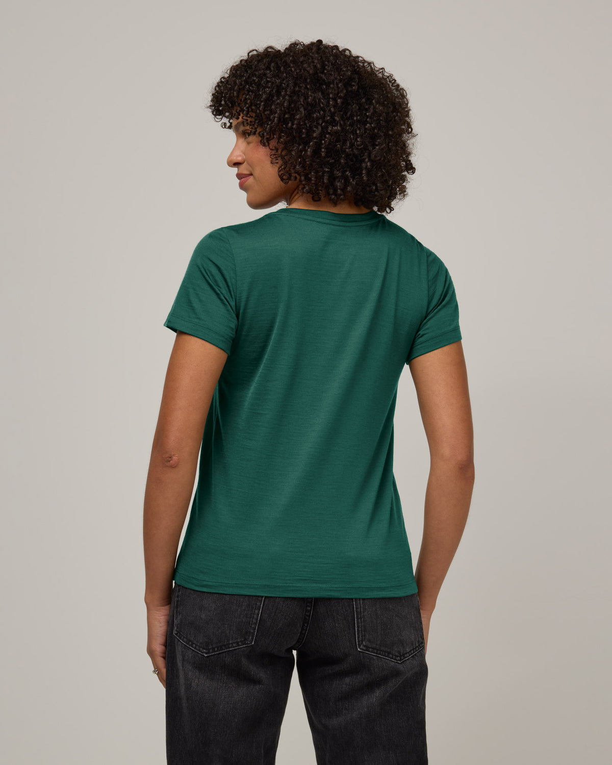 Model wearing Zoe Easy Crew Neck Tee in Emerald green. Zoe Easy Crew Neck Tee is a merino wool short sleeve, crew neck, regular fit tee available in sizes XS-3X.