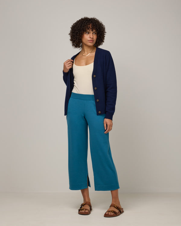Model wearing Aspen Wide Leg Crop Sweatpants in Ocean Teal, a medium blue-green color. Aspen Wide Leg Crop Sweatpants is a merino wool sweatpant with pockets available in sizes XS-3X.