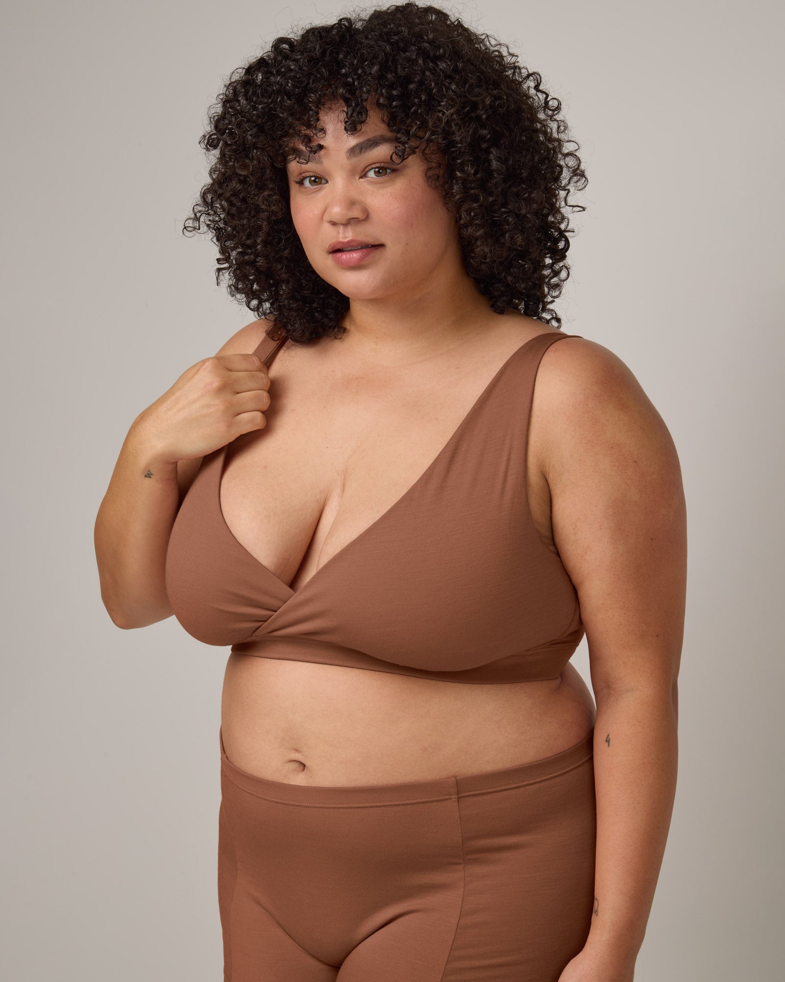 Model wearing Roam Wrap Bra in Mocha Brown, a medium-dark nude color. Roam Wrap Bra is a merino wool underwear available in sizes 1X-3X.