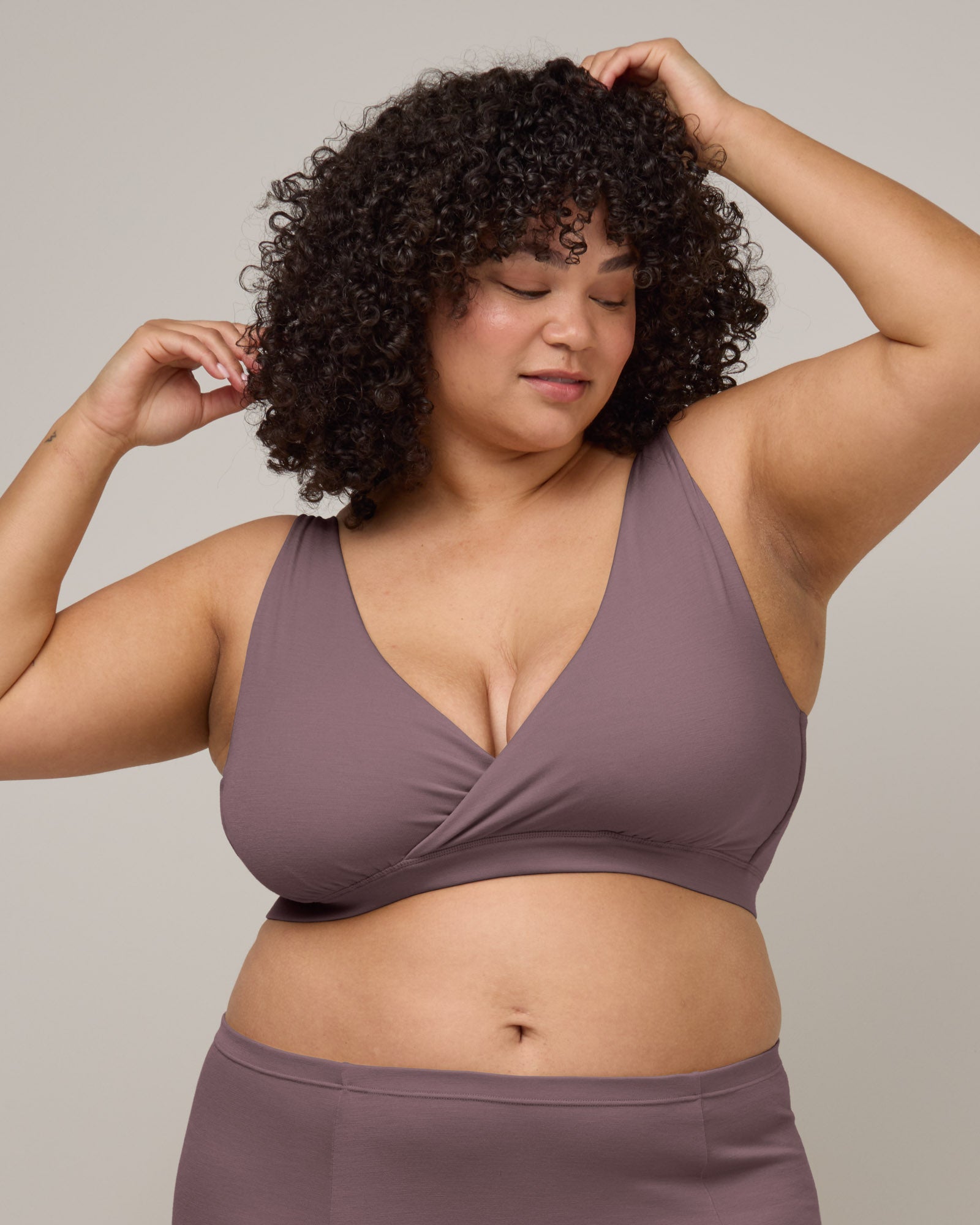 Model wearing Roam Wrap Bra in Lavender, a dusky muted purple color. Roam Wrap Bra is a merino wool underwear item available in sizes 1X-3X.