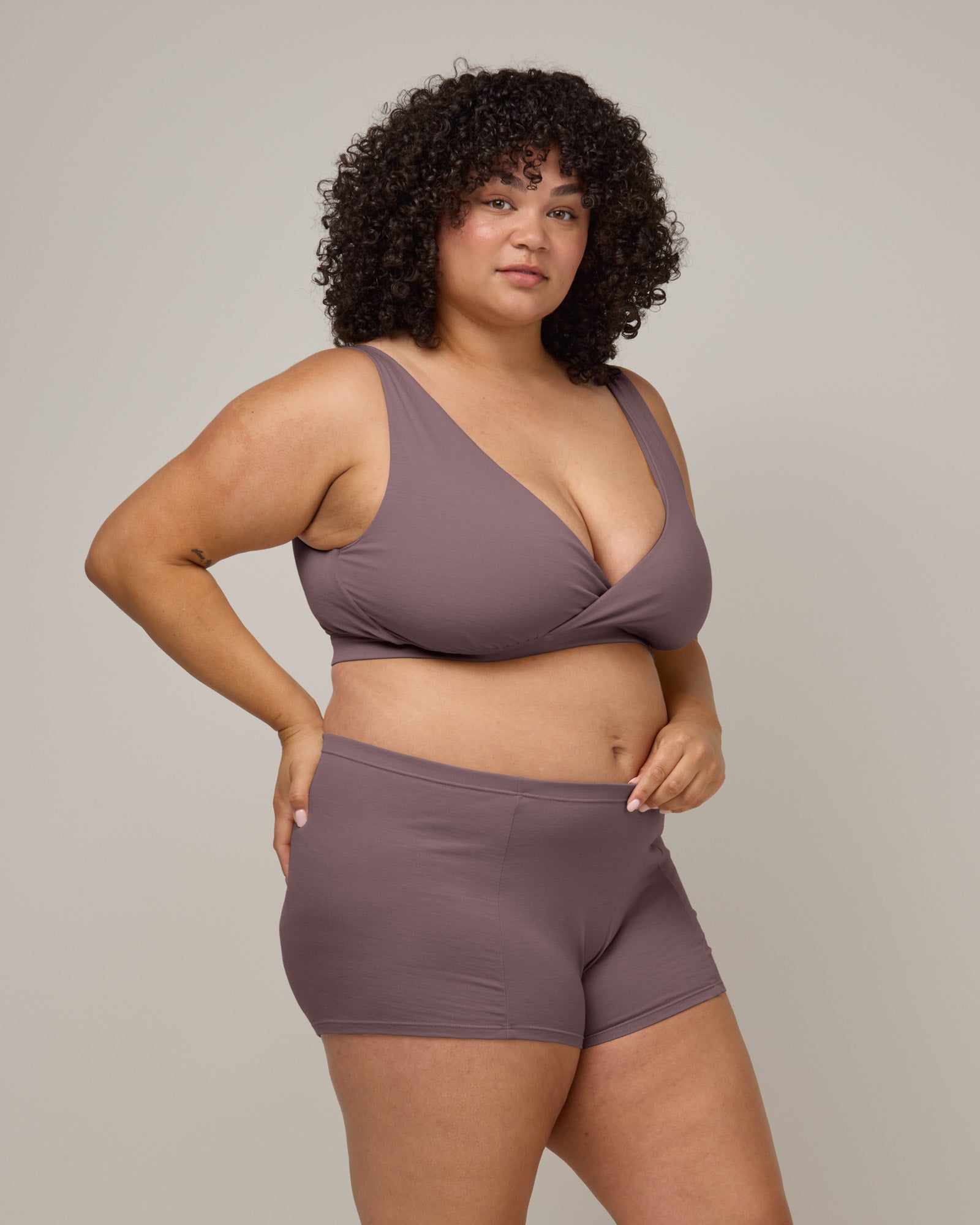 Model wearing Roam Wrap Bra in Lavender, a dusky muted purple color. Roam Wrap Bra is a merino wool underwear item available in sizes 1X-3X.