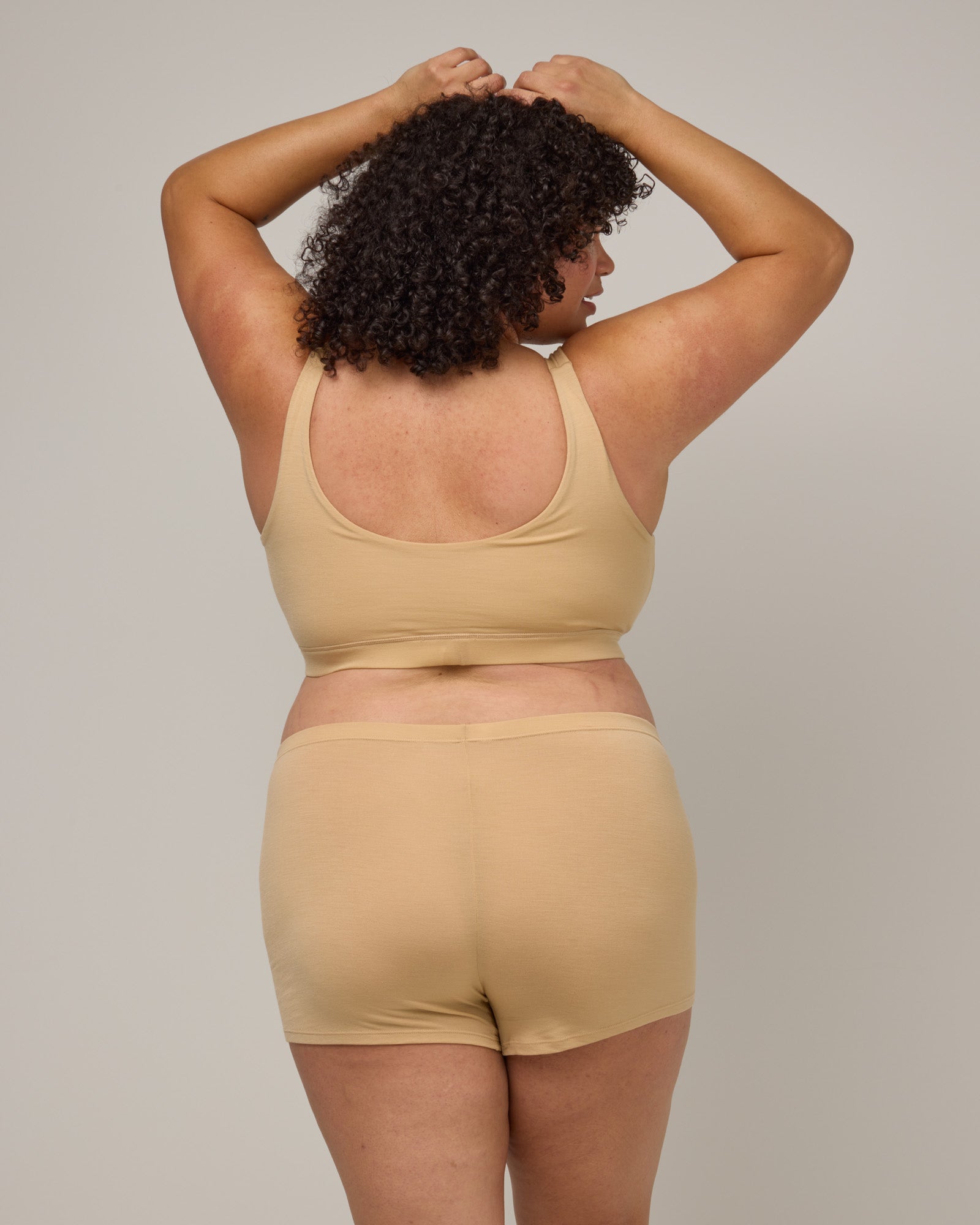 Model wearing Roam High Waist Shortie in Fawn, a light nude color. Roam High Waist Shortie is a merino wool underwear available in sizes XS-3X.