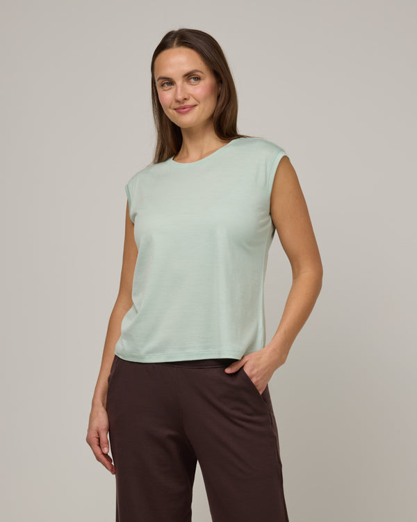 Model wearing Dawn Boxy Tank in Morning Dew, a vivid mint green color. Dawn Boxy Tank is a merino wool sleeveless, crew neck, relaxed fit top available in sizes XS-3X.