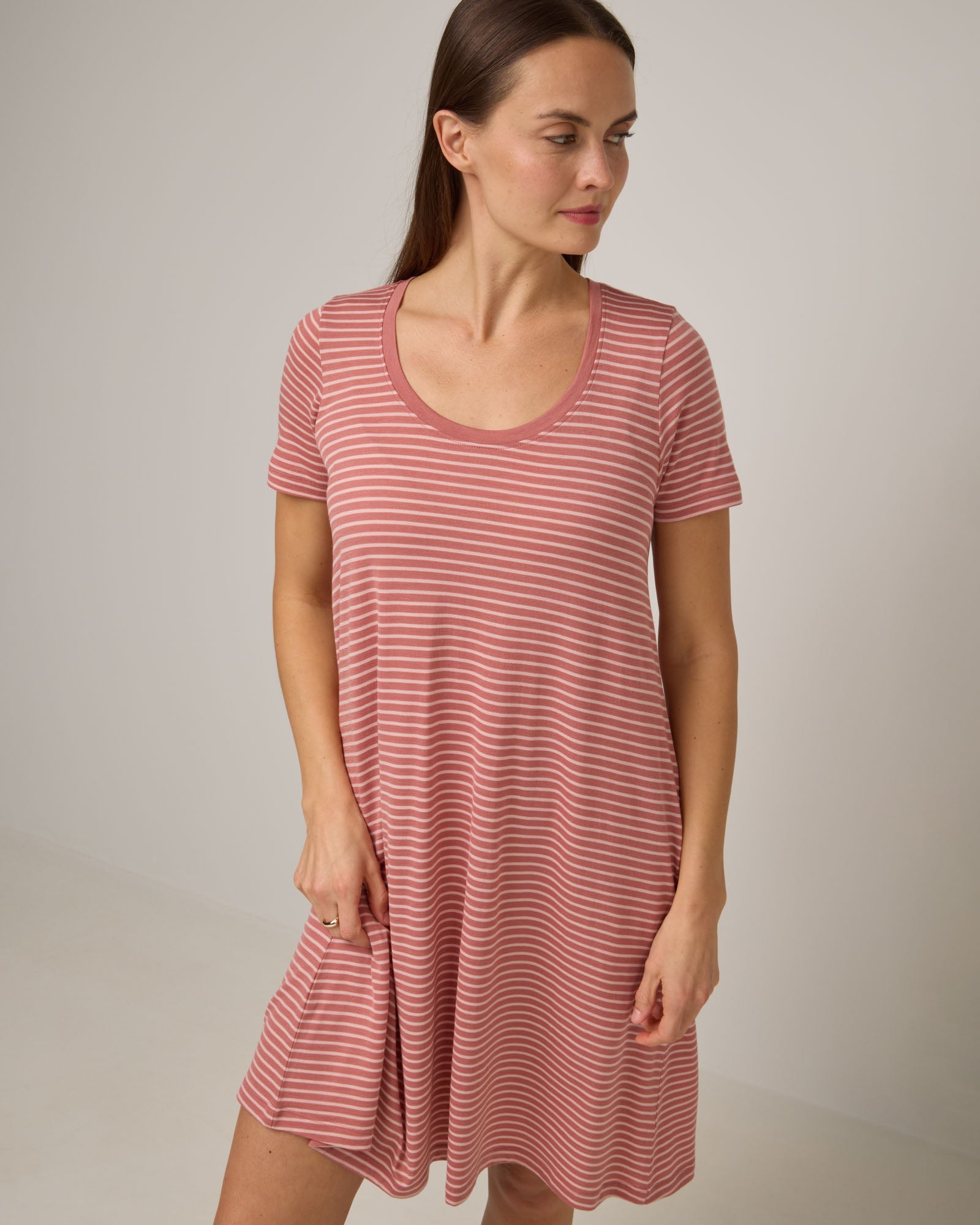 Model wearing Maggie Swing Dress in Vintage Rose & Blush Pink Stripe. Maggie Swing Dress is a merino wool short sleeve, scoop neck, knee length swing dress with pockets available in sizes XS-3X Regular, XS-3X Long.