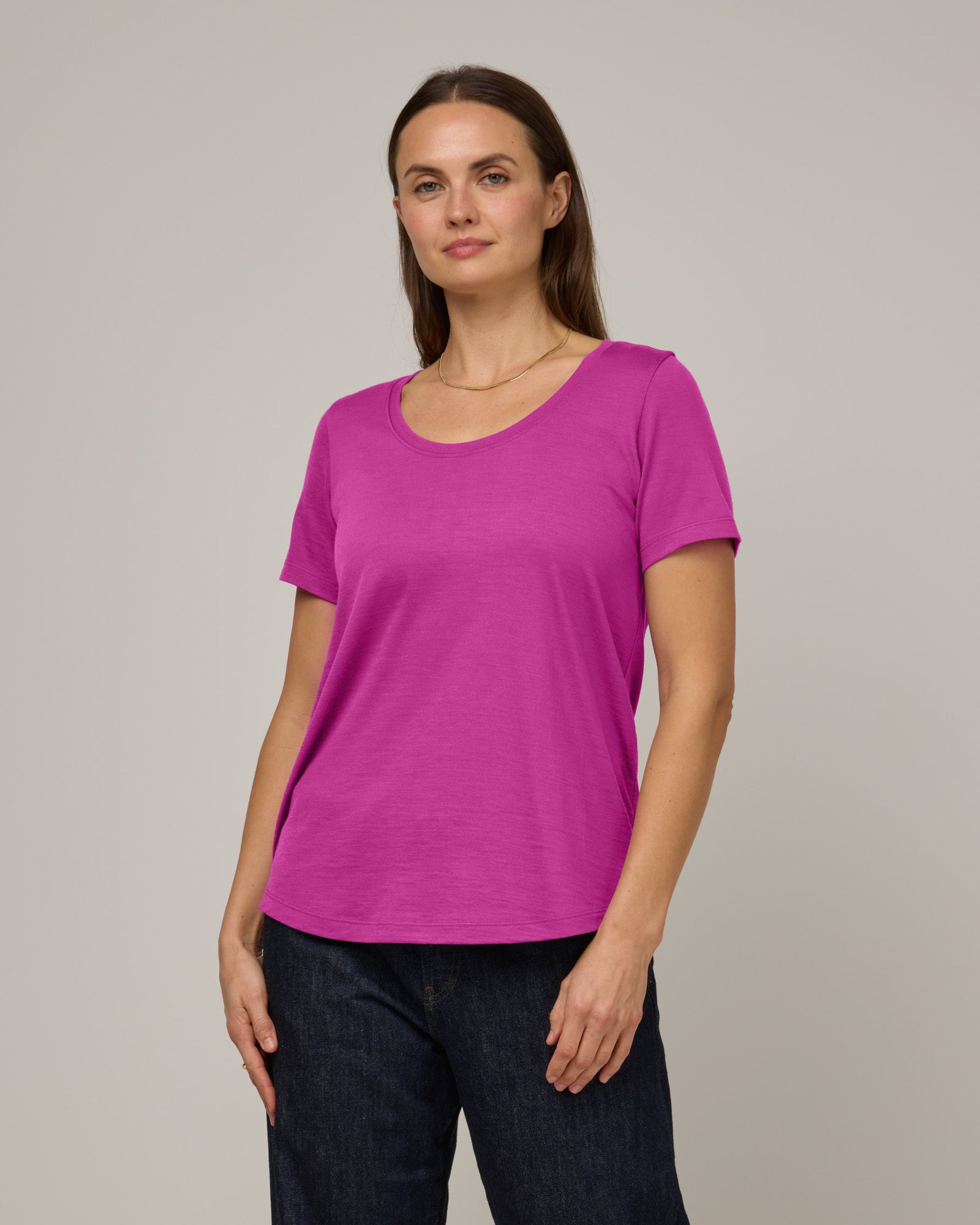 Model wearing Stella Scoop Neck Tee in Petunia, a bright fuchsia pink color. Stella Scoop Neck Tee is a merino wool short sleeve, scoop neck t-shirt available in sizes XS-3X.