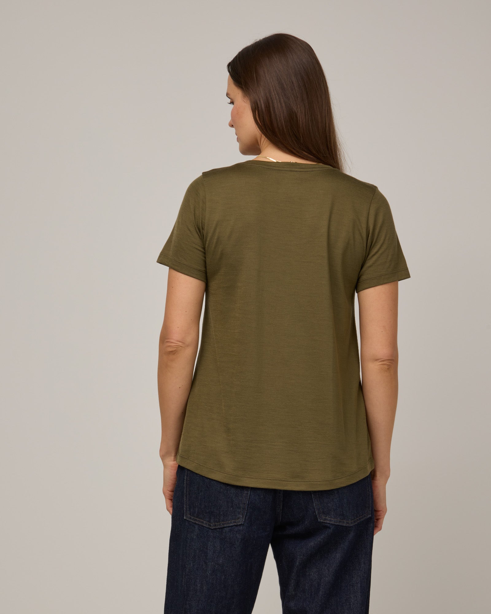 Model wearing Stella Signature Scoop Neck Tee in Olive. Stella Signature Scoop Neck Tee is a merino wool short sleeve, scoop neck, relaxed fit tee available in sizes XS-3X.