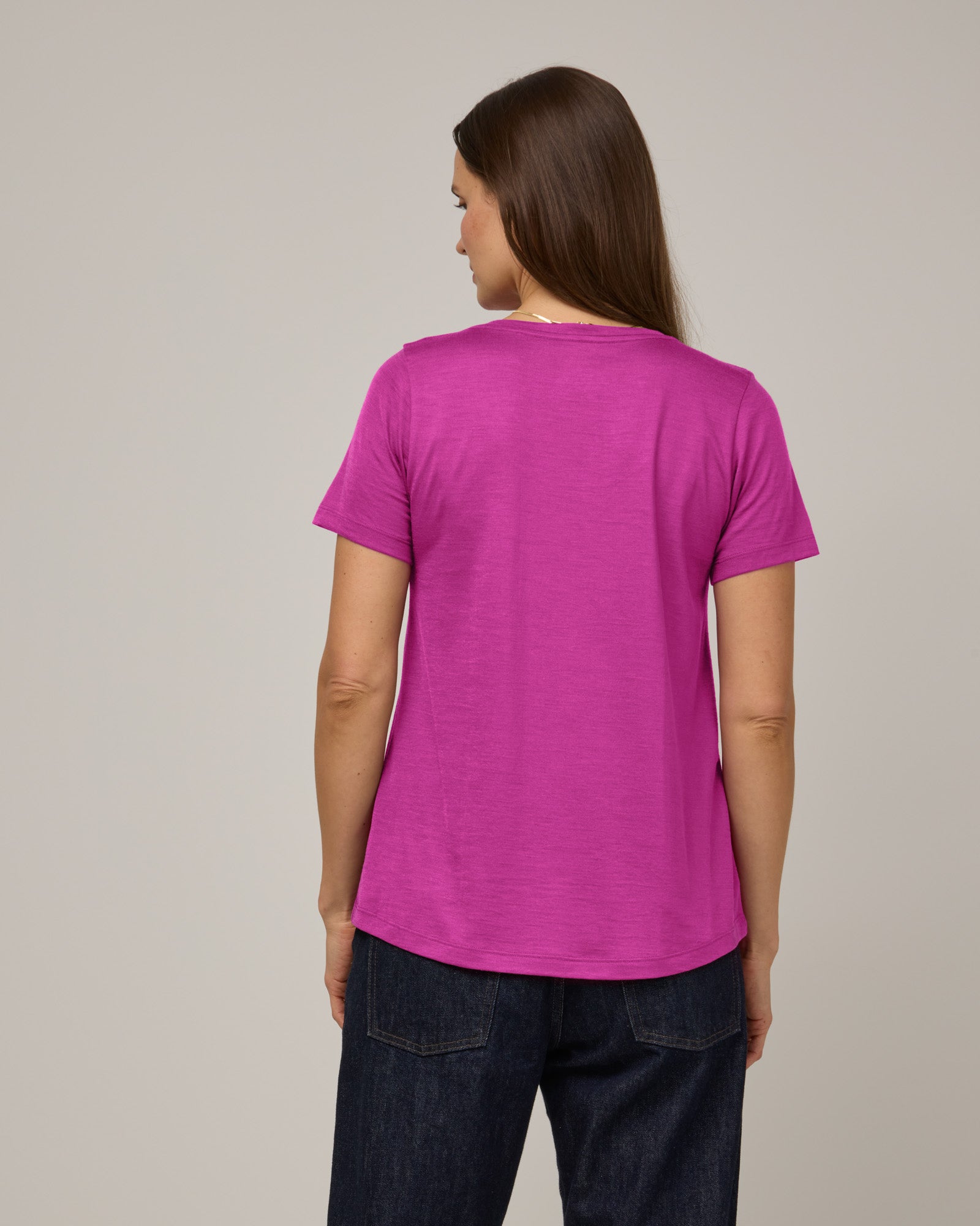 Model wearing Stella Scoop Neck Tee in Petunia, a bright fuchsia pink color. Stella Scoop Neck Tee is a merino wool short sleeve, scoop neck t-shirt available in sizes XS-3X.