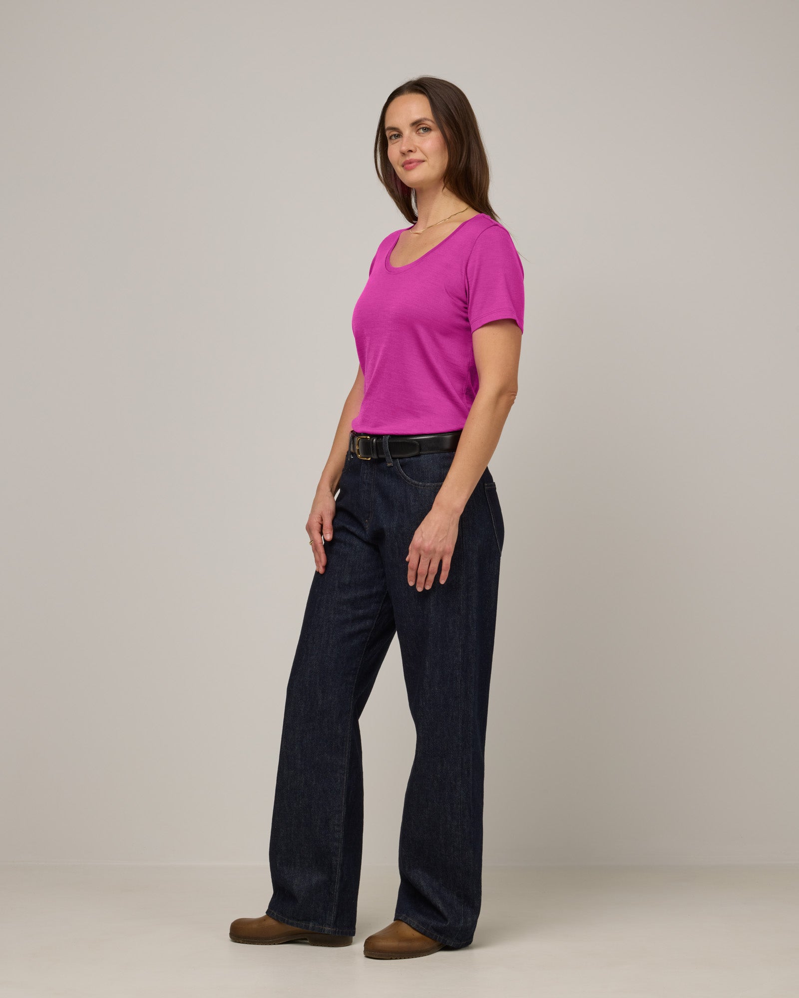 Model wearing Stella Scoop Neck Tee in Petunia, a bright fuchsia pink color. Stella Scoop Neck Tee is a merino wool short sleeve, scoop neck t-shirt available in sizes XS-3X.