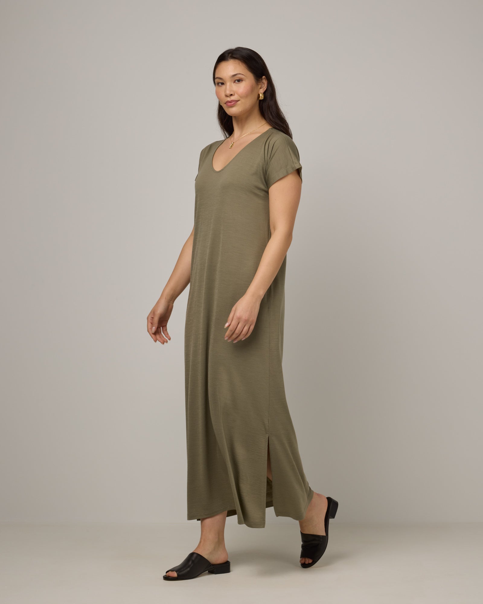 Model wearing Freya Maxi Dress in Sage Green, a soft muted green color. Freya Maxi Dress is a merino wool short sleeve, v-neck, maxi swing dress with pockets available in sizes XS-3X.