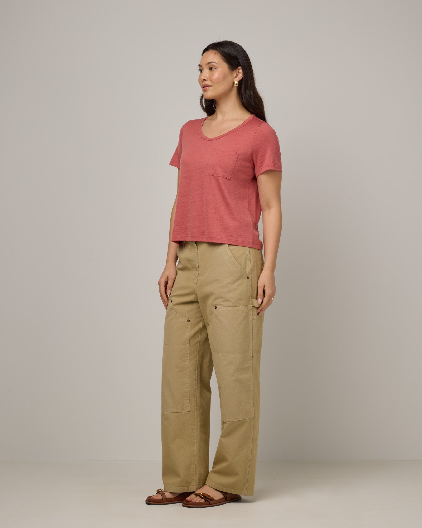 Model wearing Hailee Boxy Tee in Dusty Cedar, a soft pink-coral color. Hailee Boxy Tee is a merino wool short sleeve, crew neck, relaxed fit tee available in sizes XS-3X.