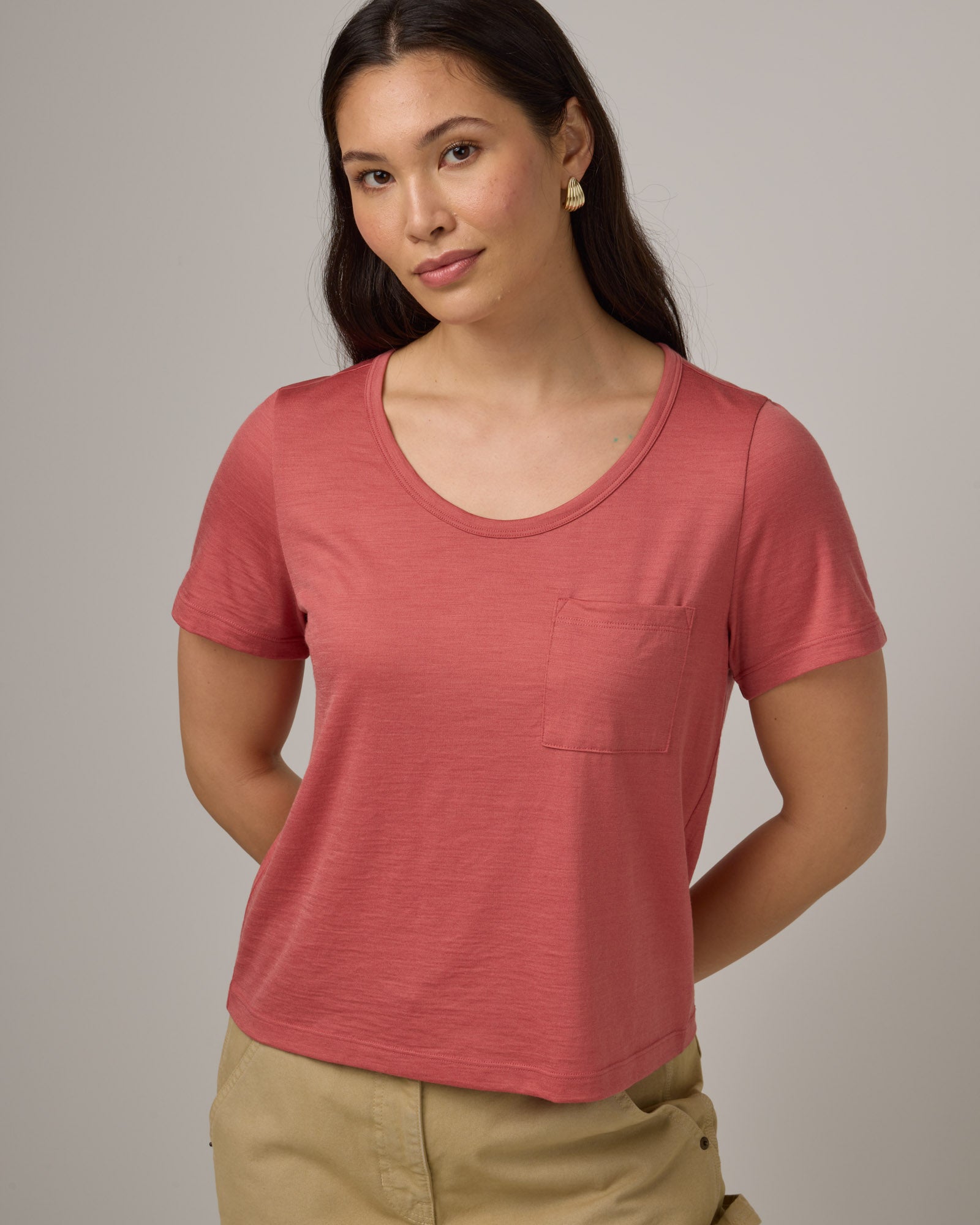 Model wearing Hailee Boxy Tee in Dusty Cedar, a soft pink-coral color. Hailee Boxy Tee is a merino wool short sleeve, crew neck, relaxed fit tee available in sizes XS-3X.
