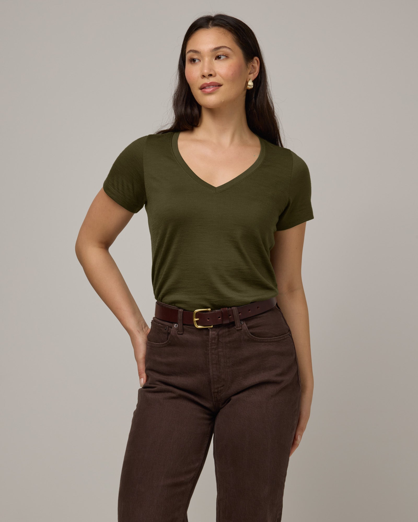 Model wearing Morgan V-Neck Tee in Forest Night, a muted dark green color. Morgan V-Neck Tee is a merino wool short sleeve, v-neck, regular fit tee available in sizes XS-3X.