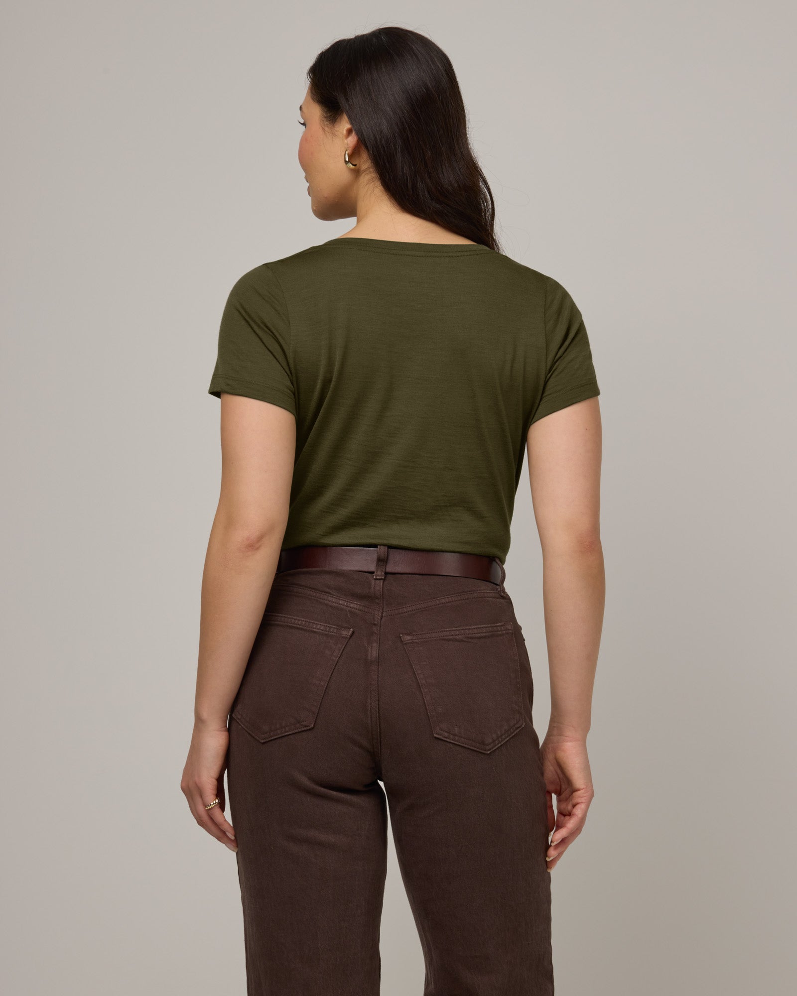 Model wearing Morgan V-Neck Tee in Forest Night, a muted dark green color. Morgan V-Neck Tee is a merino wool short sleeve, v-neck, regular fit tee available in sizes XS-3X.
