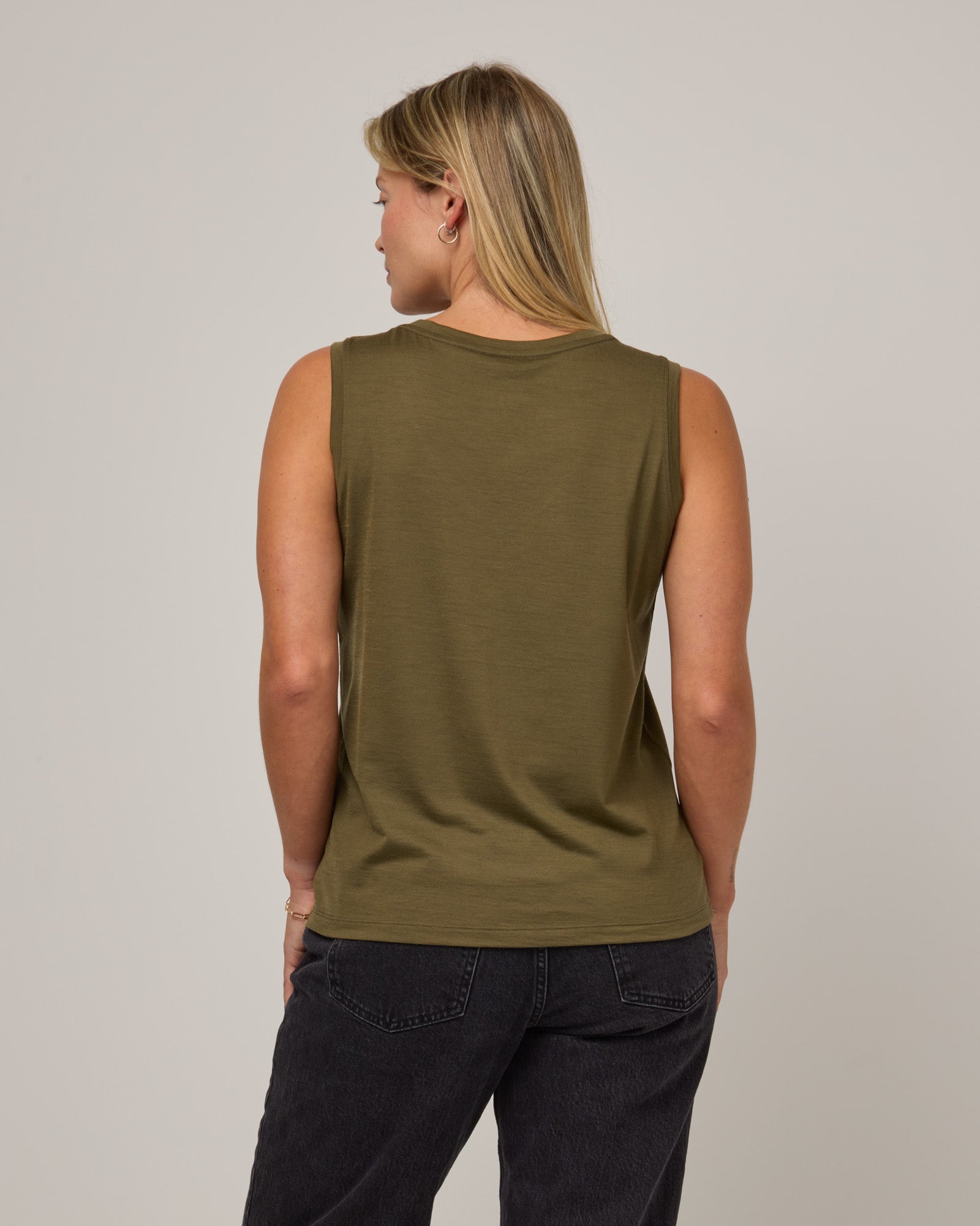 Model wearing Penelope Pocket Tank in Olive. Penelope Pocket Tank is a merino wool sleeveless, v-neck tank with a pocket available in sizes XS-3X.