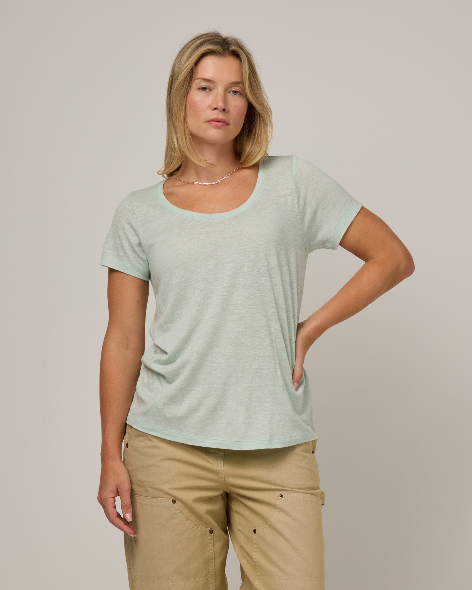 Model wearing Stella Linen Scoop Neck Tee in Morning Dew, a bright mint green color. Stella Linen Scoop Neck Tee is a merino wool short sleeve, scoop neck, relaxed fit tee available in sizes XS-3X.