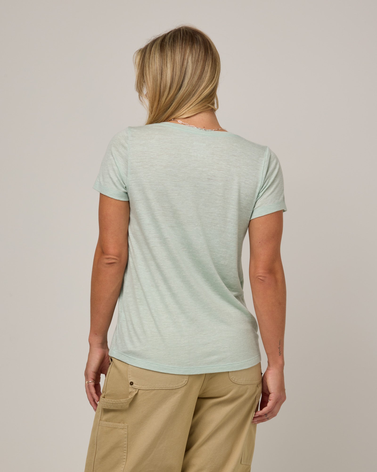 Model wearing Stella Linen Scoop Neck Tee in Morning Dew, a bright mint green color. Stella Linen Scoop Neck Tee is a merino wool short sleeve, scoop neck, relaxed fit tee available in sizes XS-3X.