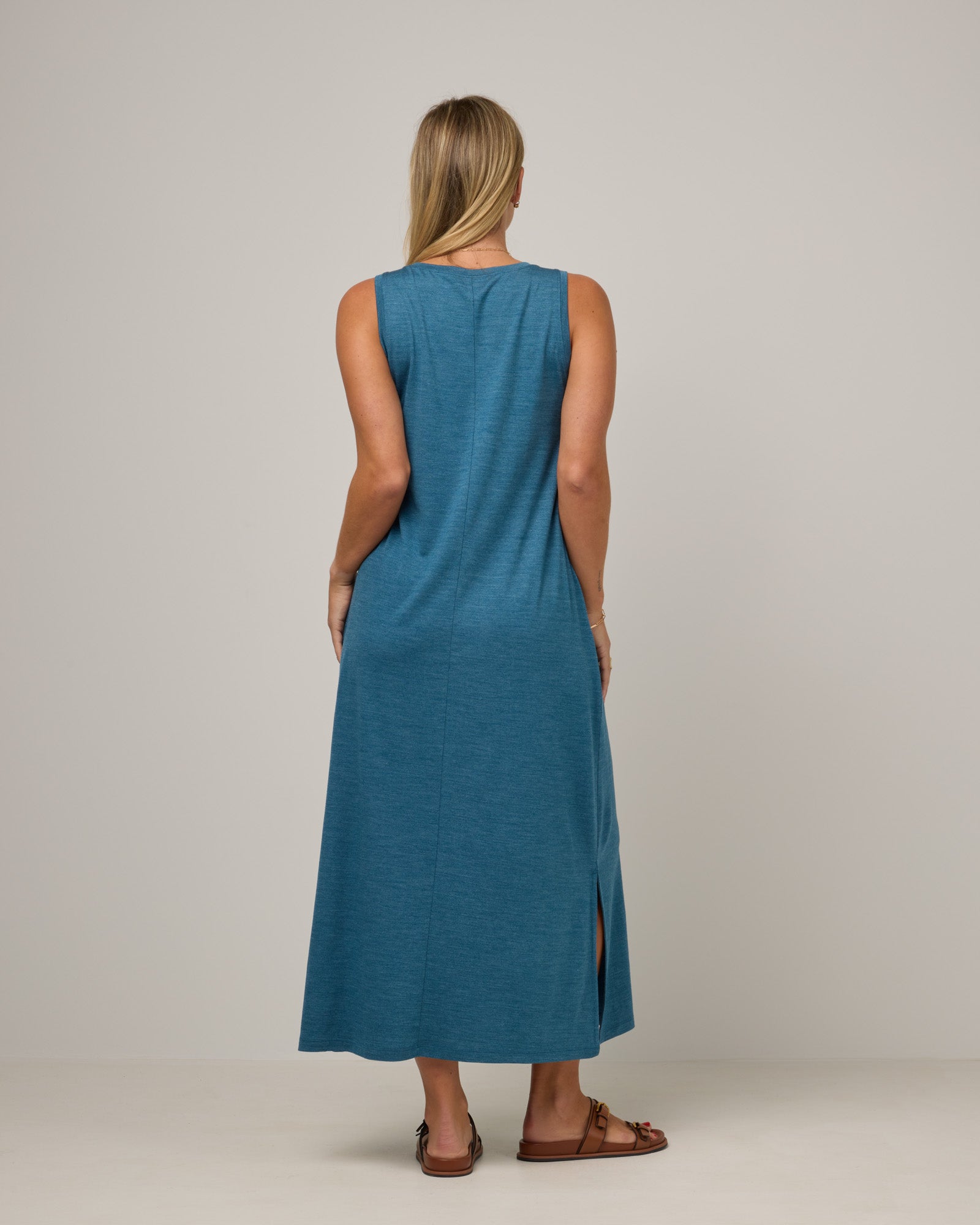 Model wearing Audrey TENCEL™ Maxi Dress in Ocean Teal Heather, a medium blue-green color. Audrey TENCEL™ Maxi Dress is a merino wool sleeveless, scoop neck, maxi shift dress with pockets available in sizes XS-3X.
