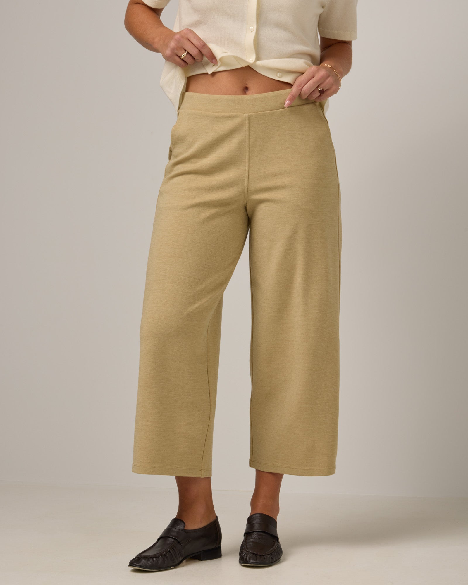 Model wearing Frame Ponte Culotte in Sahara, a warm, sandy tan neutral color. Frame Ponte Culotte is a merino wool pant with pockets available in sizes XS-3X Regular, XS-XL Petite.
