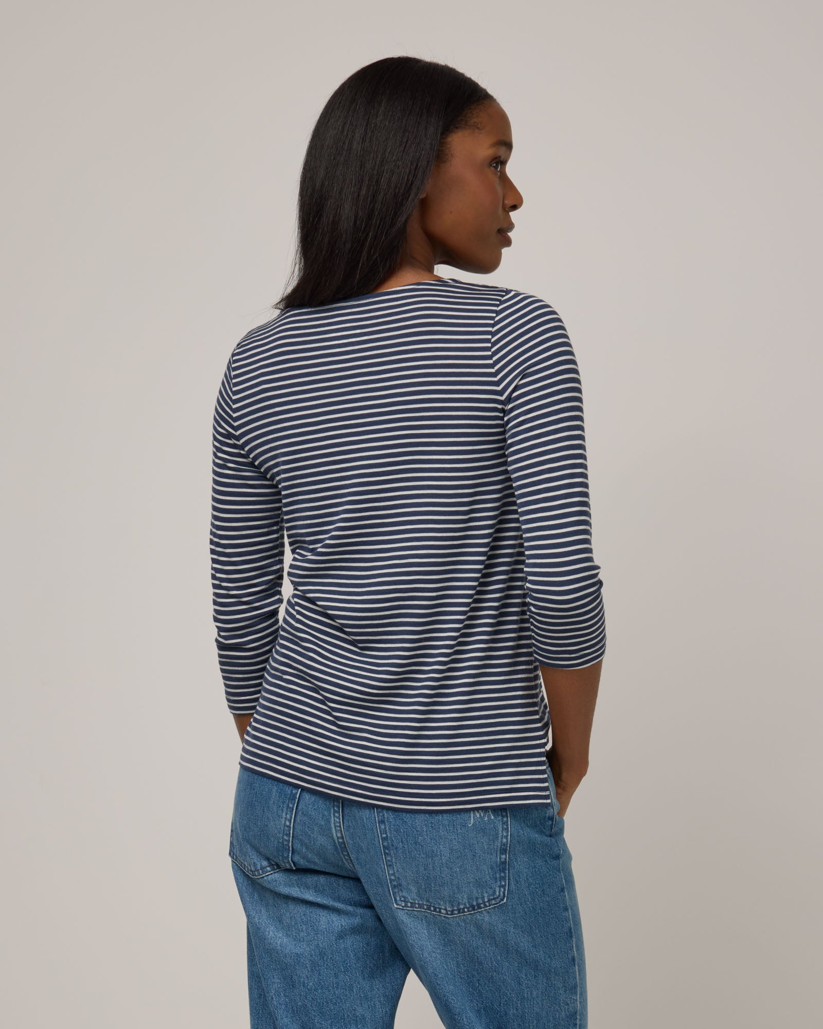 Model wearing Colette Quarter-Sleeve Top in Marine Blue & Natural White Stripe. Colette Quarter-Sleeve Top is a merino wool long sleeve, boatneck, regular fit top available in sizes XS-3X.