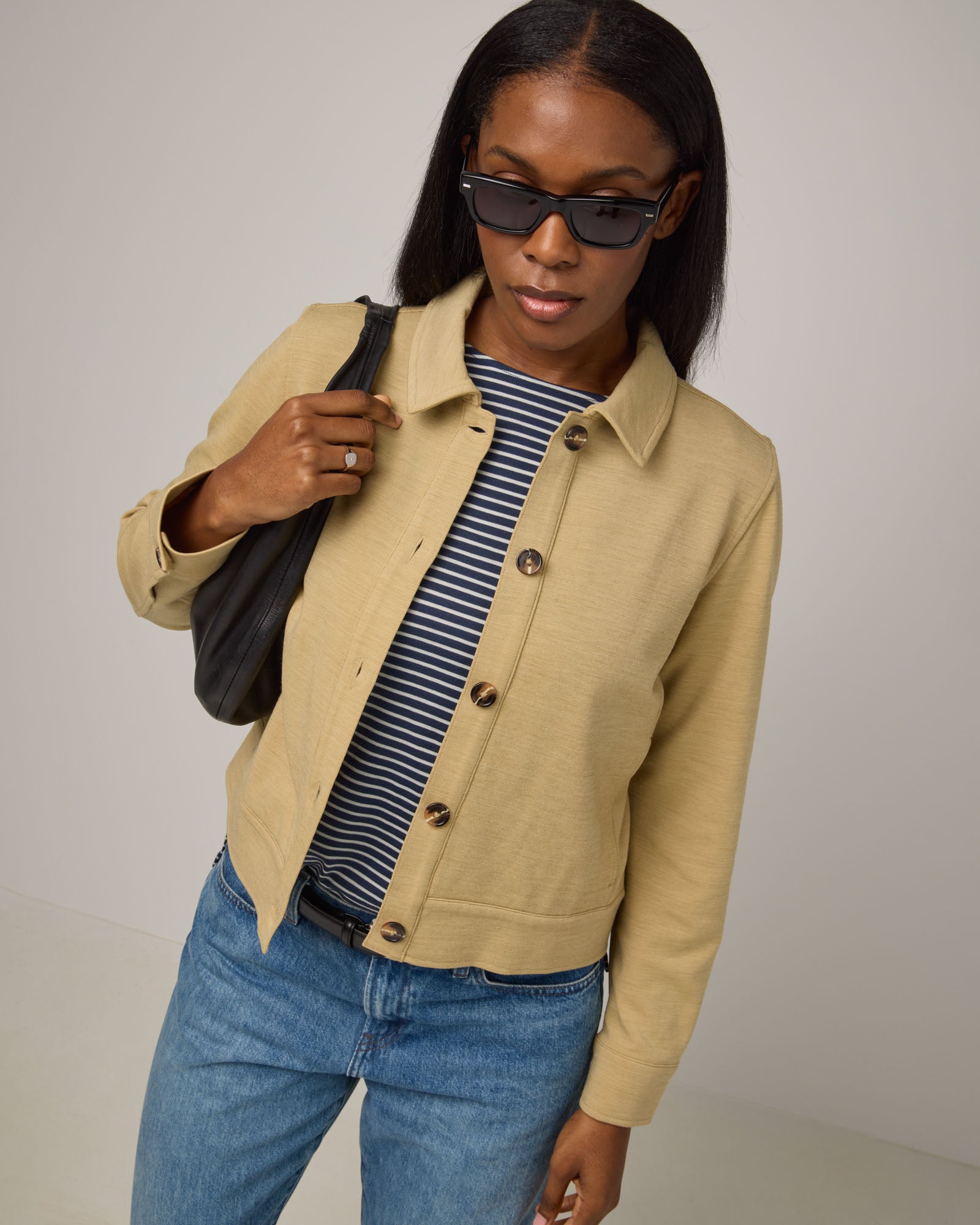 Model wearing Johnny Ponte Jacket in Sahara, a warm, sandy tan neutral color. Johnny Ponte Jacket is a merino wool long sleeve, collared, jacket with pockets available in sizes XS-XXL.