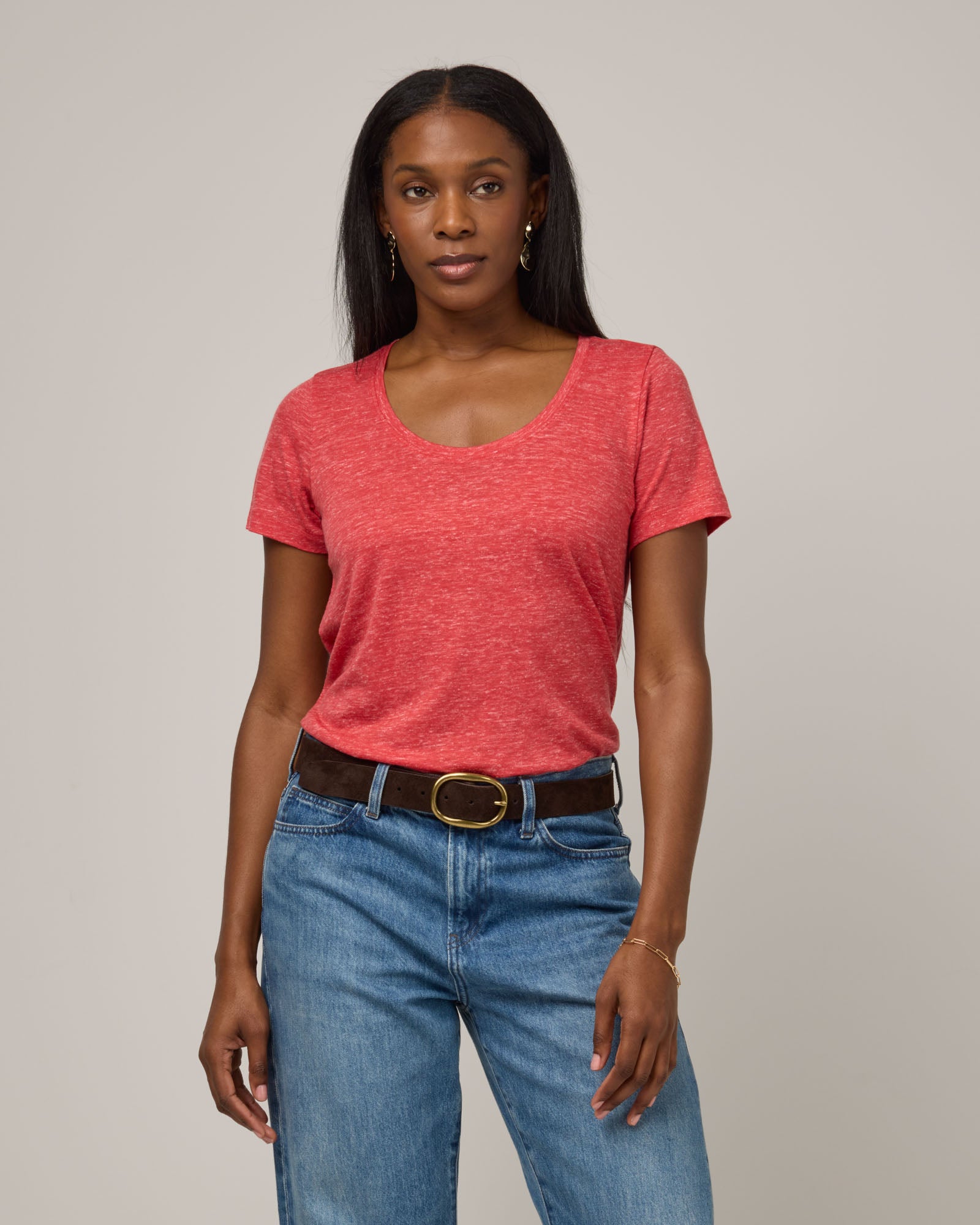 Model wearing Stella Linen Scoop Neck Tee in Fruit Punch, a vivid red-orange color. Stella Linen Scoop Neck Tee is a merino wool short sleeve, scoop neck, relaxed fit tee available in sizes XS-3X.
