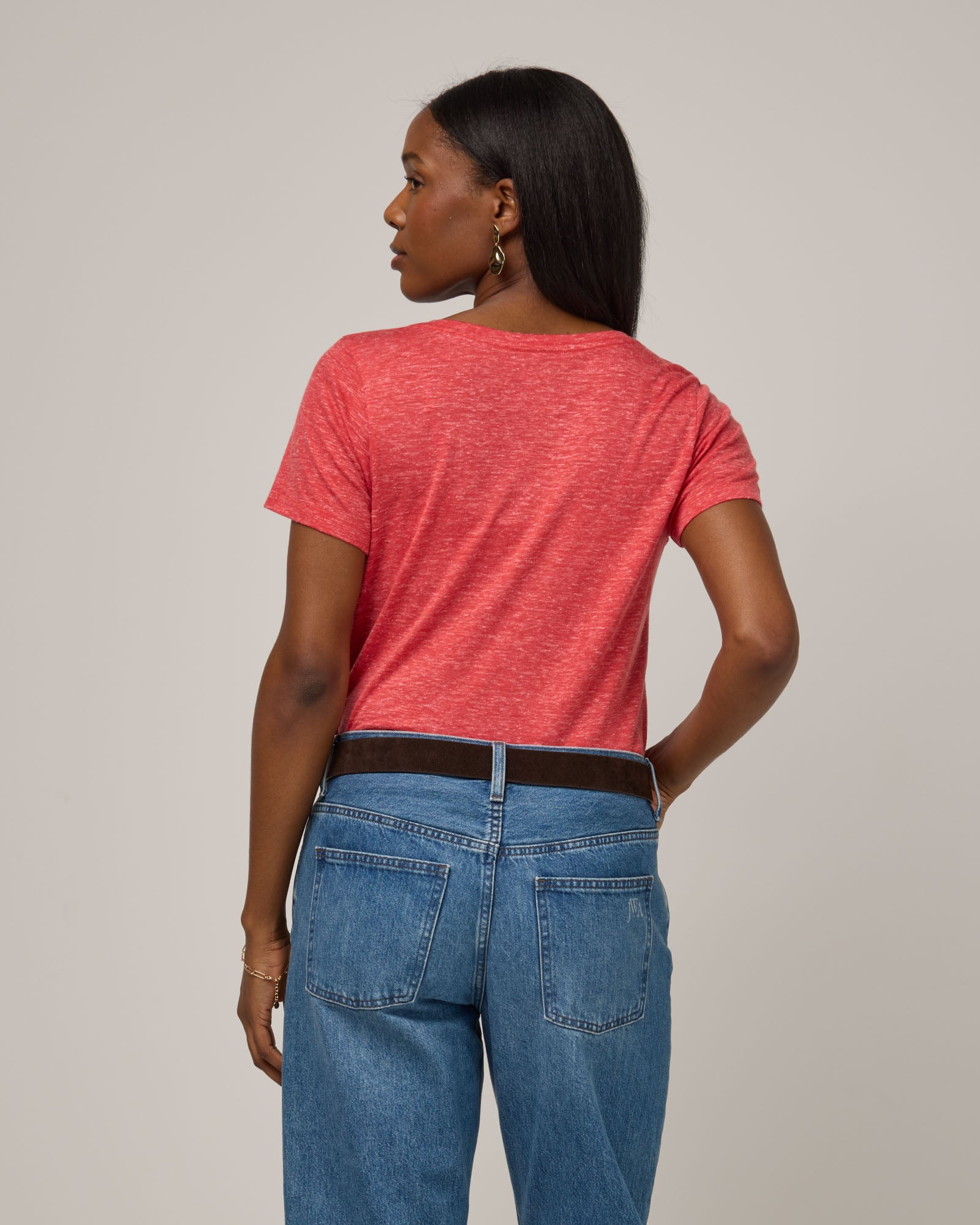 Model wearing Stella Linen Scoop Neck Tee in Fruit Punch, a vivid red-orange color. Stella Linen Scoop Neck Tee is a merino wool short sleeve, scoop neck, relaxed fit tee available in sizes XS-3X.