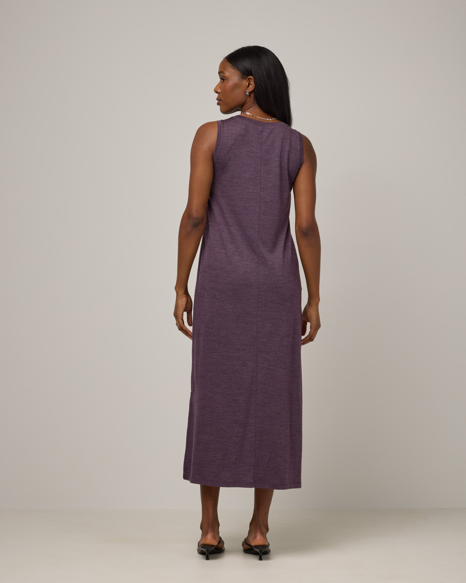 Model wearing Audrey TENCEL™ Maxi Dress in Marionberry Heather, a deep berry purple color. Audrey TENCEL™ Maxi Dress is a merino wool sleeveless, scoop neck, maxi shift dress with pockets available in sizes XS-3X.