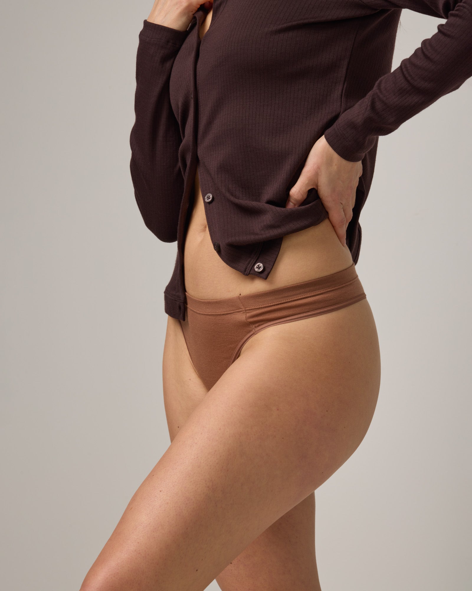 Model wearing Roam Thong in Mocha Brown, a medium-dark nude color. Roam Thong is a merino wool underwear available in sizes XS-3X