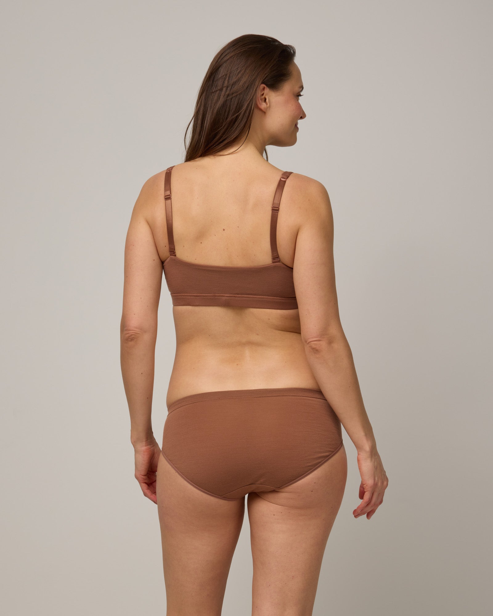 Model wearing Roam Bikini in Mocha Brown, a medium-dark nude color. Roam Bikini is a merino wool underwear available in sizes XS-3X.