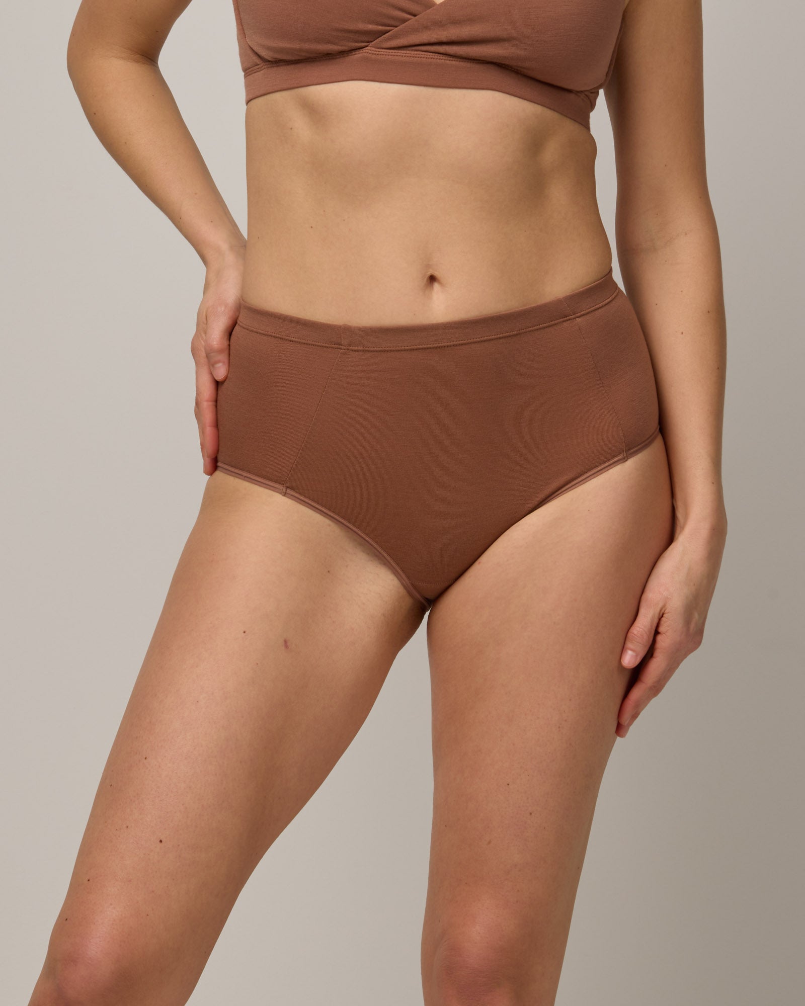 Model wearing Roam High Waist Bikini in Mocha Brown, a medium-dark nude color. Roam High Waist Bikini is a merino wool underwear available in sizes XS-3X.