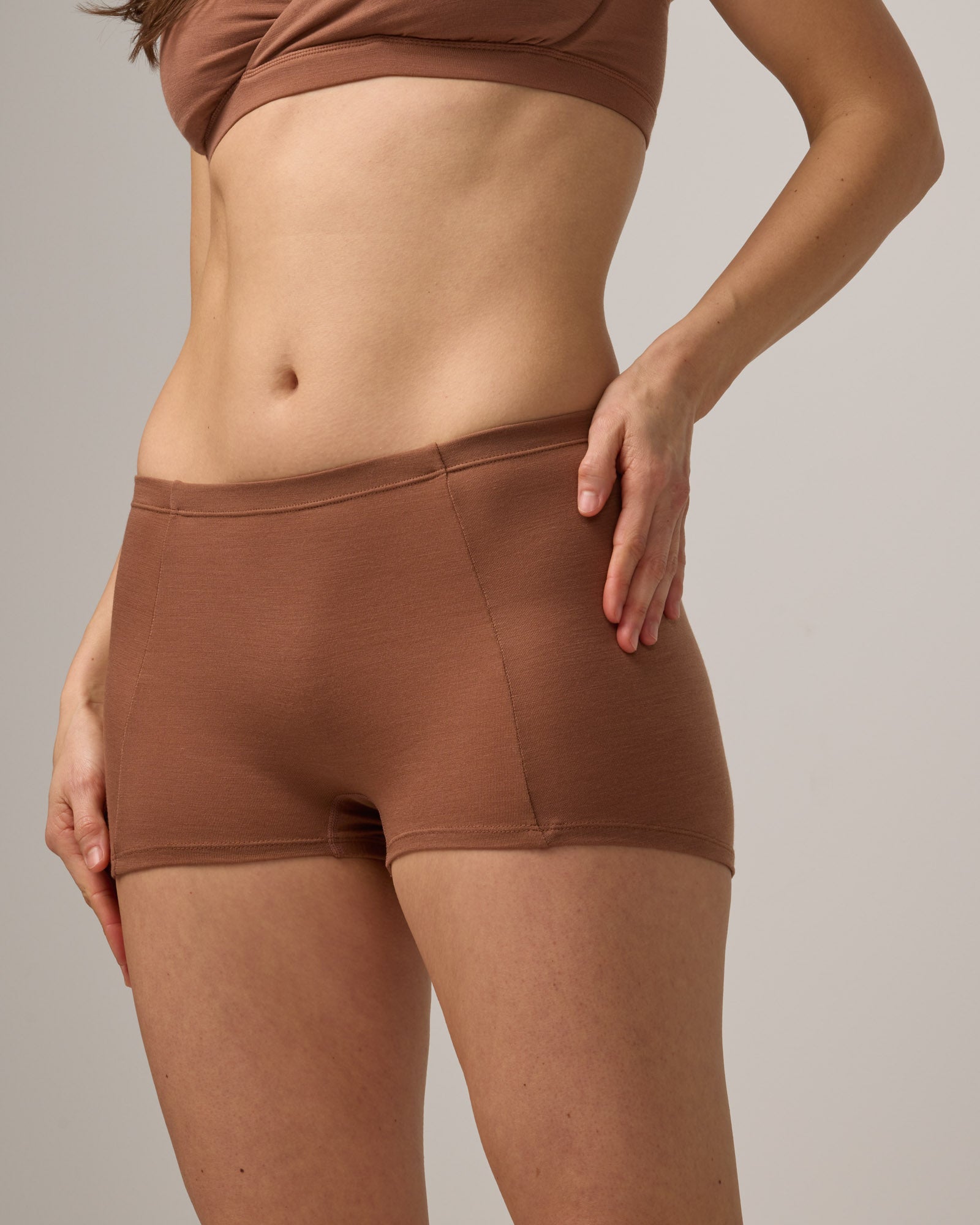 Model wearing Roam High Waist Shortie in Mocha Brown, a medium-dark nude color. Roam High Waist Shortie is a merino wool underwear available in sizes XS-3X.