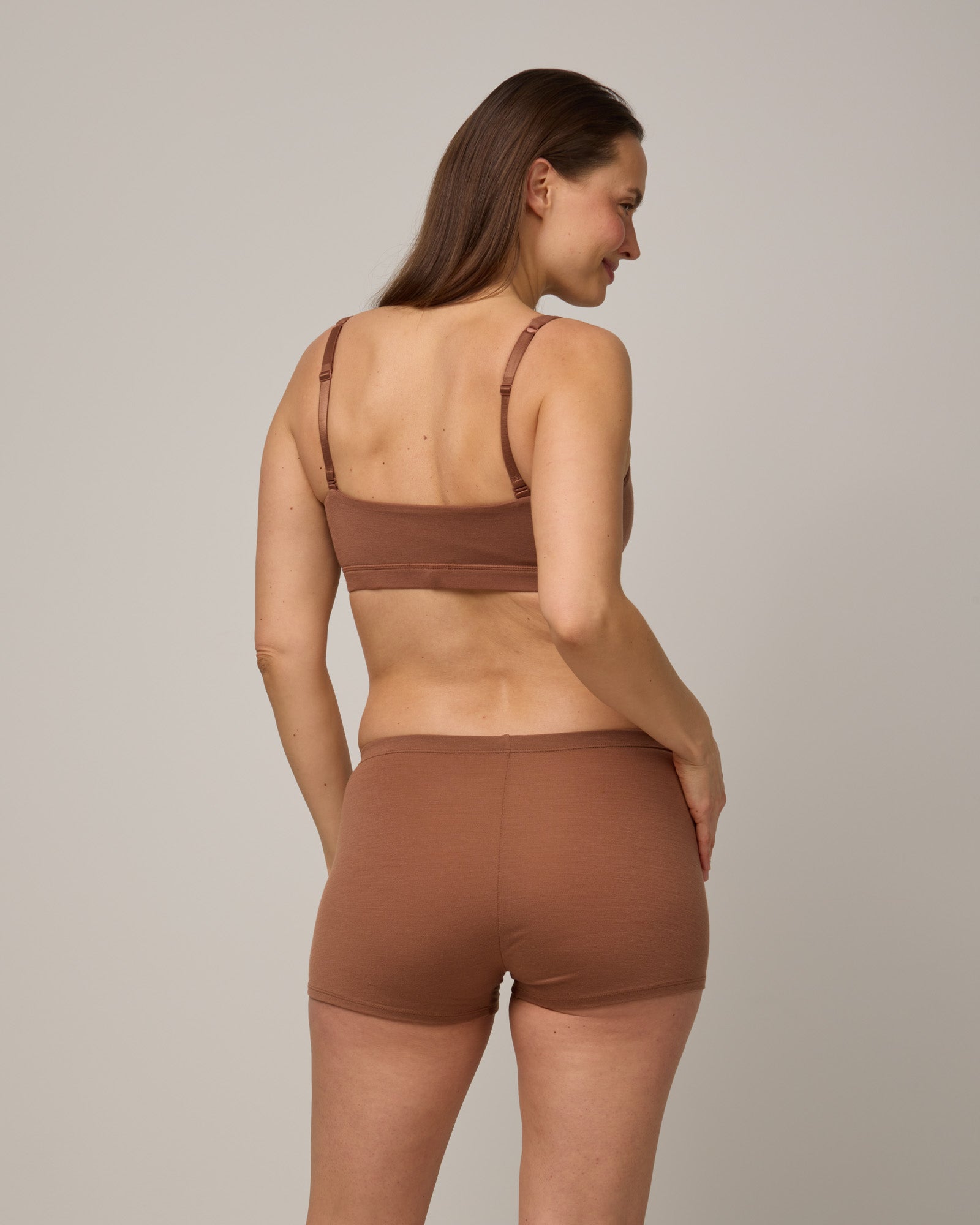 Model wearing Roam High Waist Shortie in Mocha Brown, a medium-dark nude color. Roam High Waist Shortie is a merino wool underwear available in sizes XS-3X.