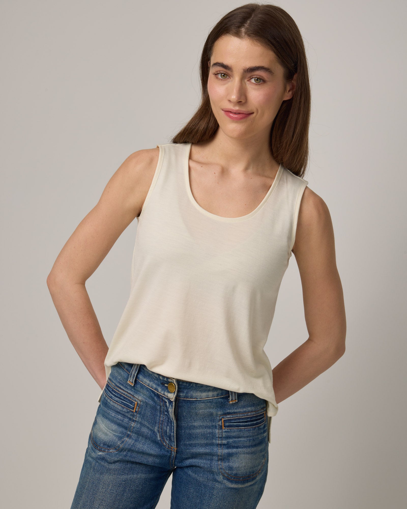 Model wearing Steph Scoop Neck Tank in Natural White. Steph Scoop Neck Tank is a merino wool sleeveless tank available in sizes XS-3X.  
