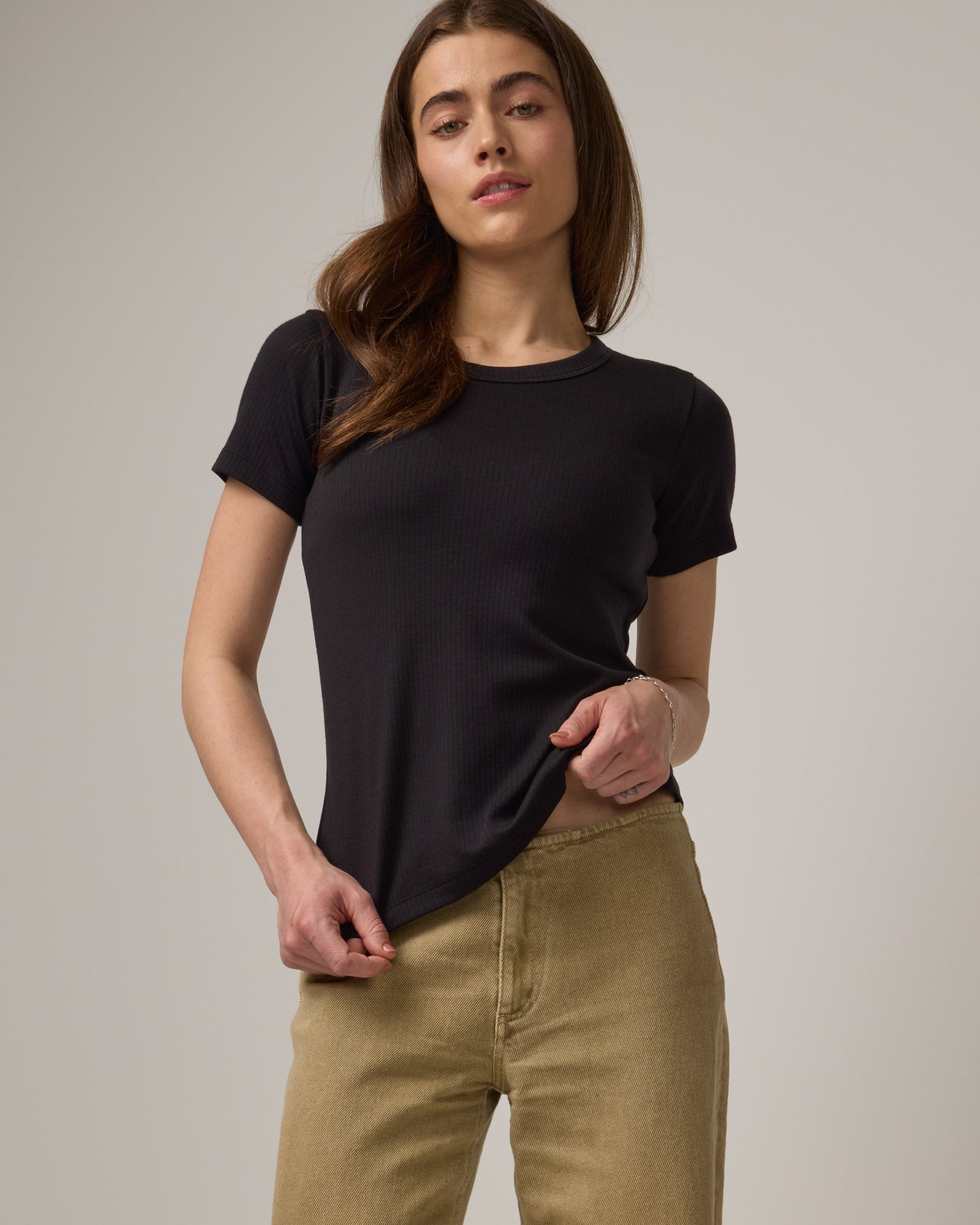 Model wearing Taylor Ribbed Tee in Black. Taylor Ribbed Tee is a merino wool short sleeve, crew neck tee available in sizes XS-3X. 